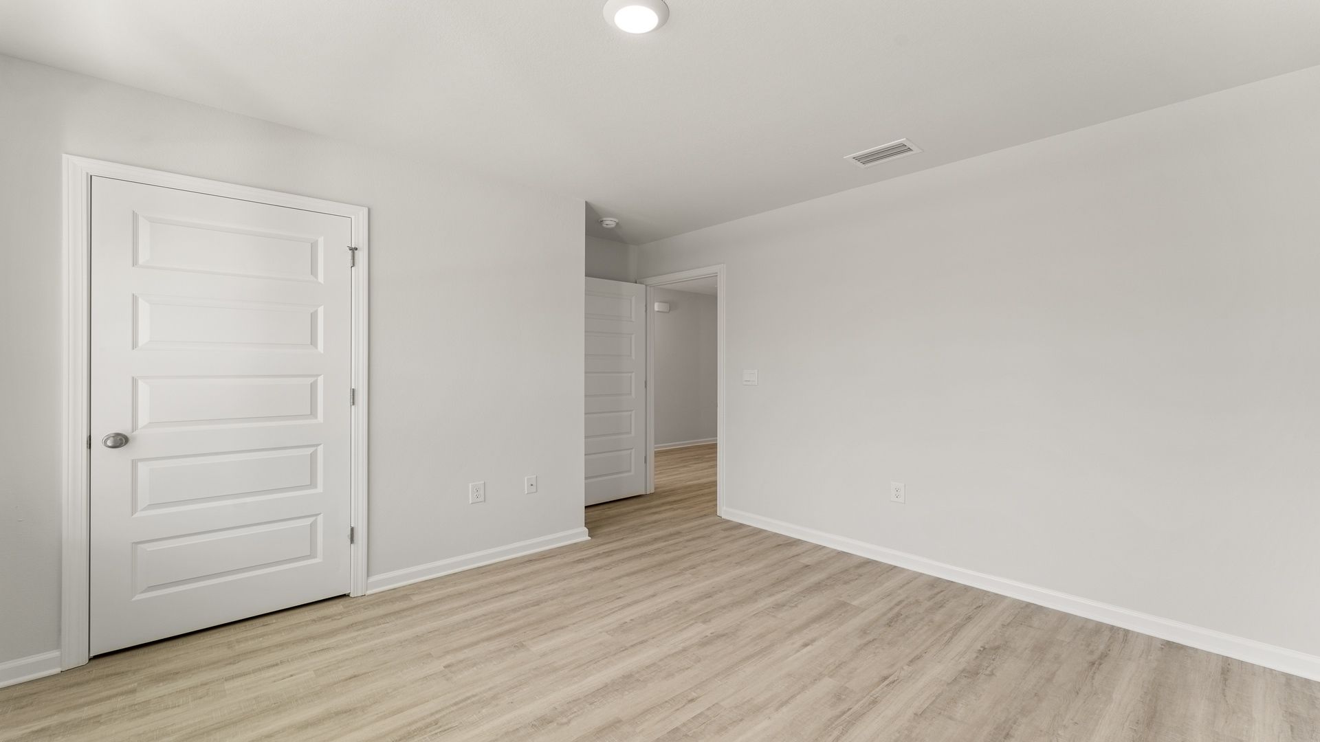 Bedroom with EVP flooring and closet.