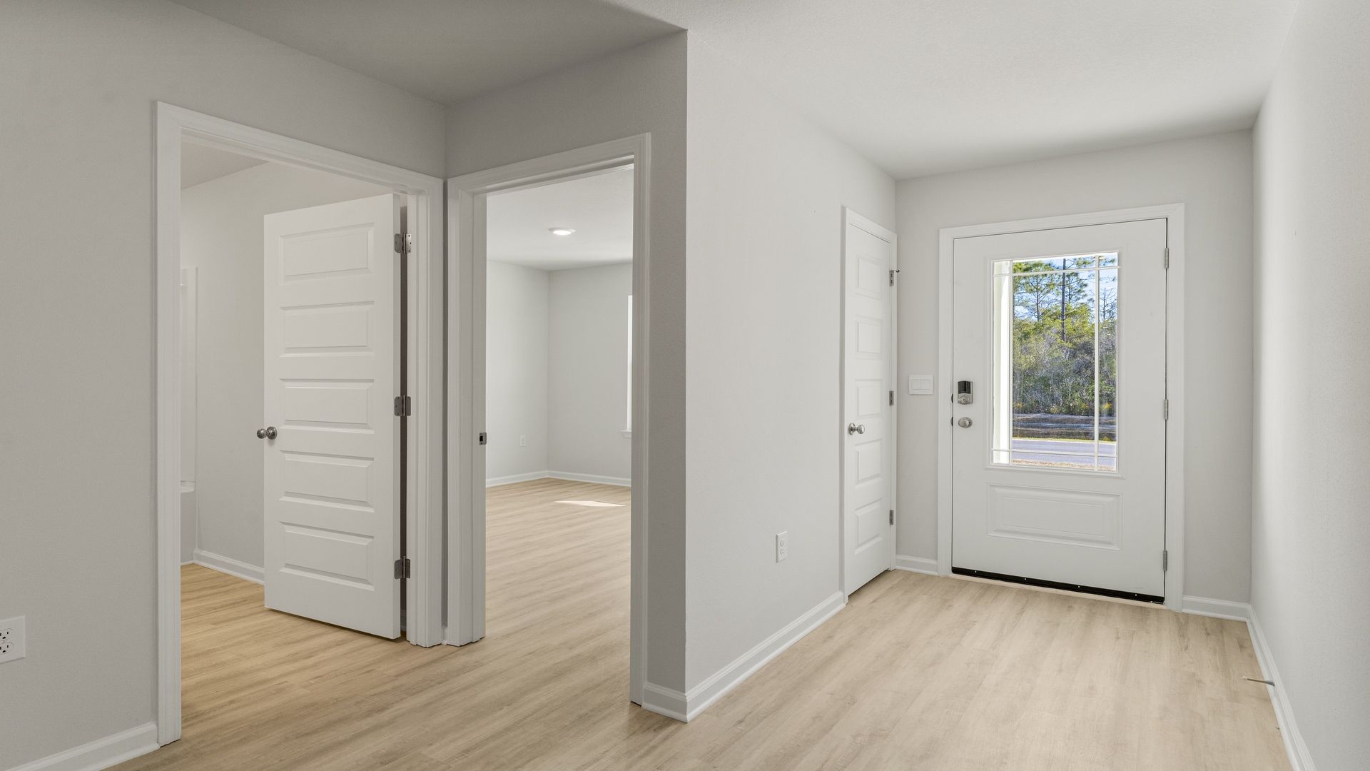 Front entrance by front door and bathroom and 2 bedrooms with EVP flooring.