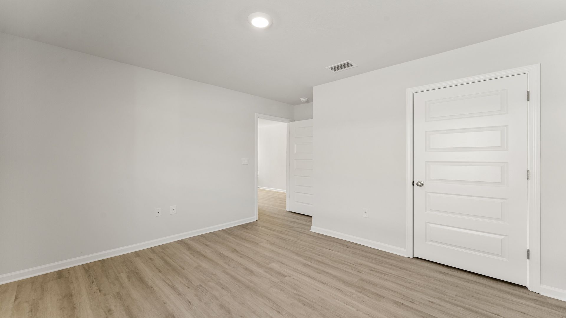 Bedroom with EVP flooring and closet.