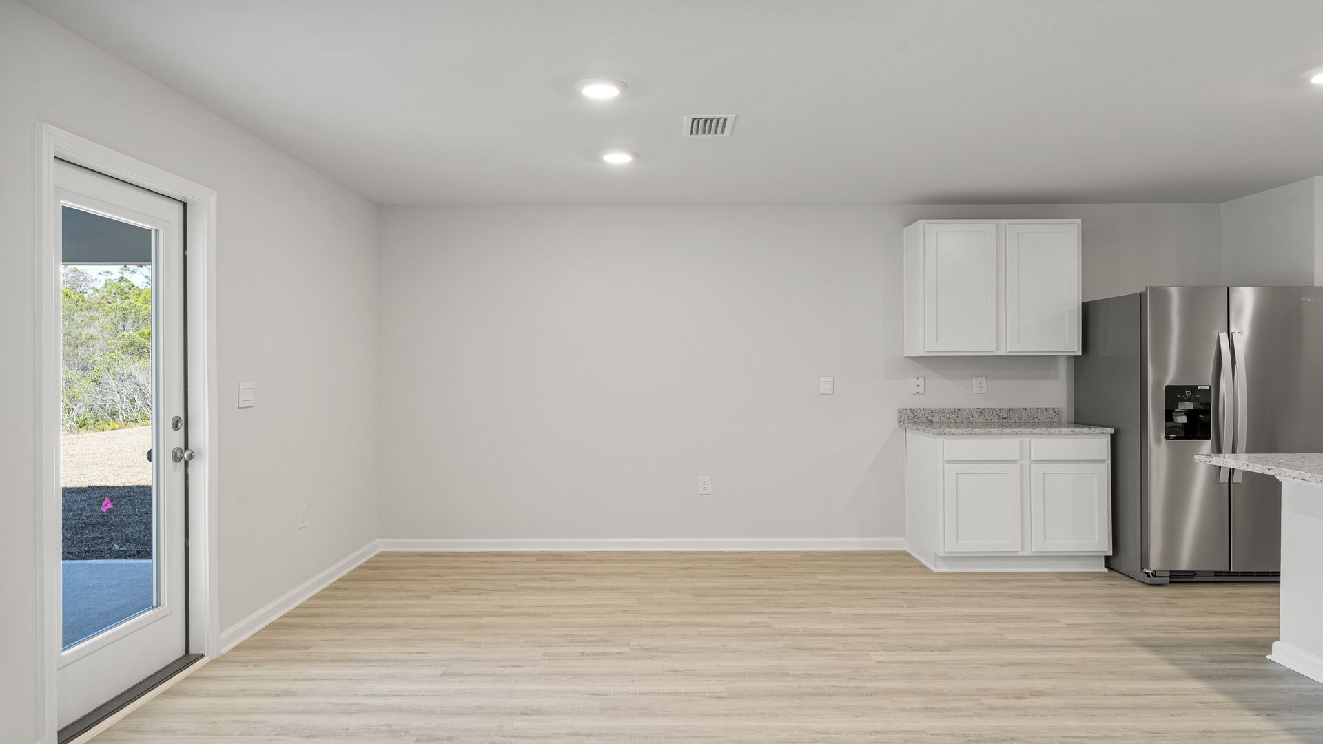Dining area with EVP flooring and back door next to kitchen.