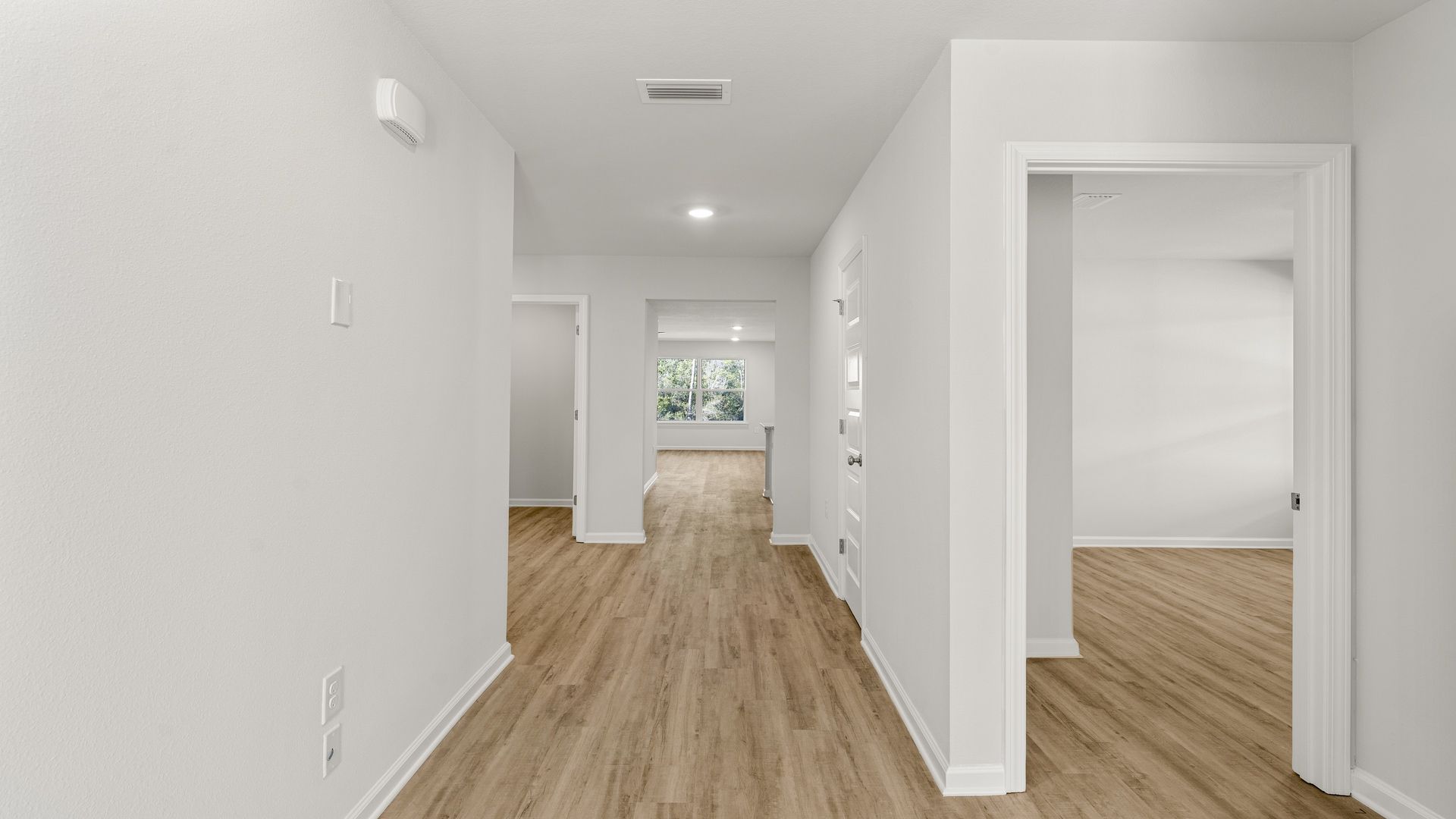 Front hallway by front door and bathroom and 2 bedrooms with EVP flooring.