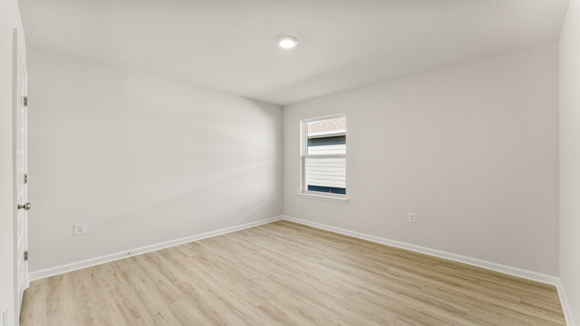 Bedroom with EVP flooring and window.