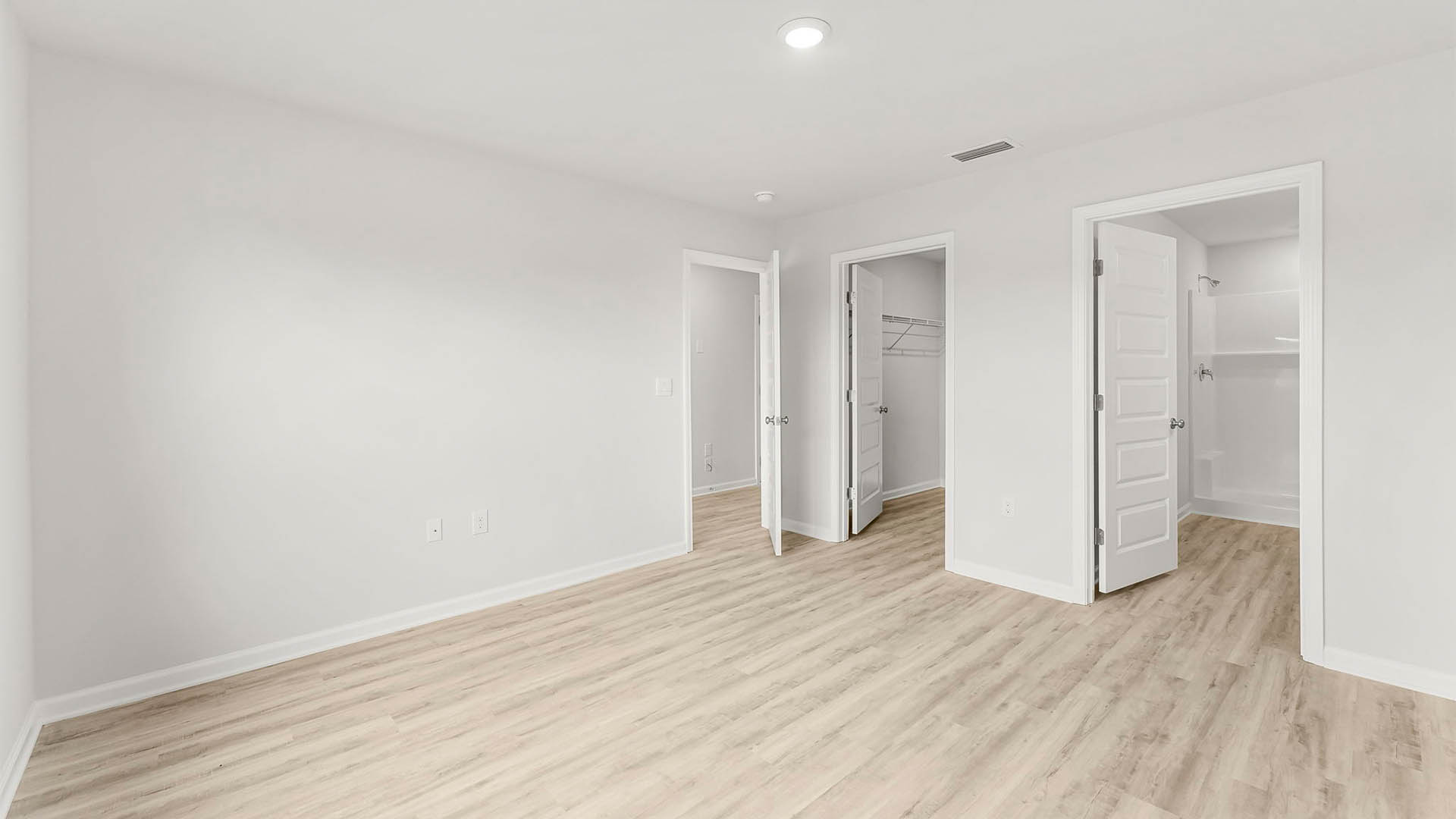 Primary bedroom with EV flooring and bathroom and close entrance.