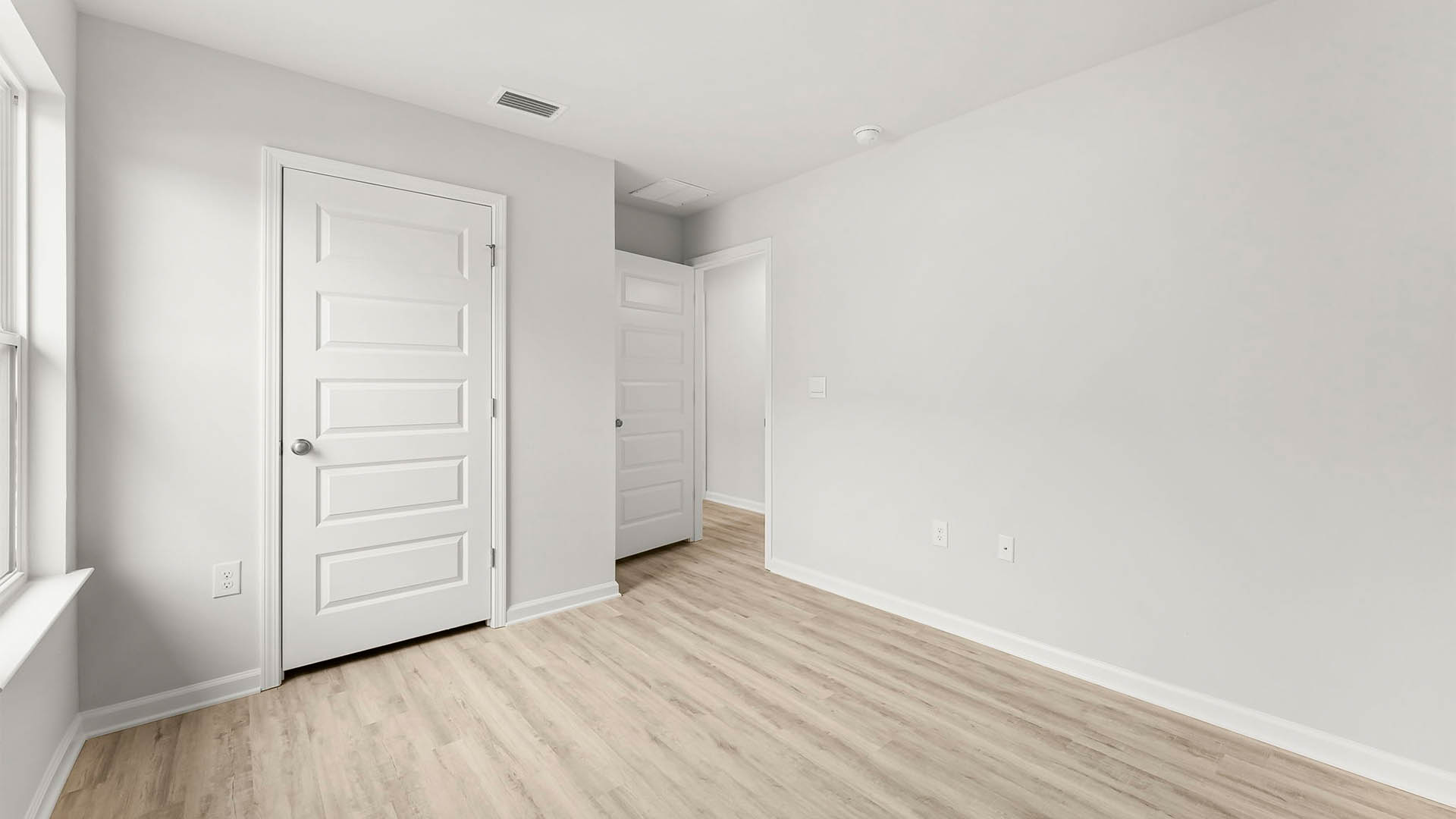 Bedroom with EVP flooring and window and closet.
