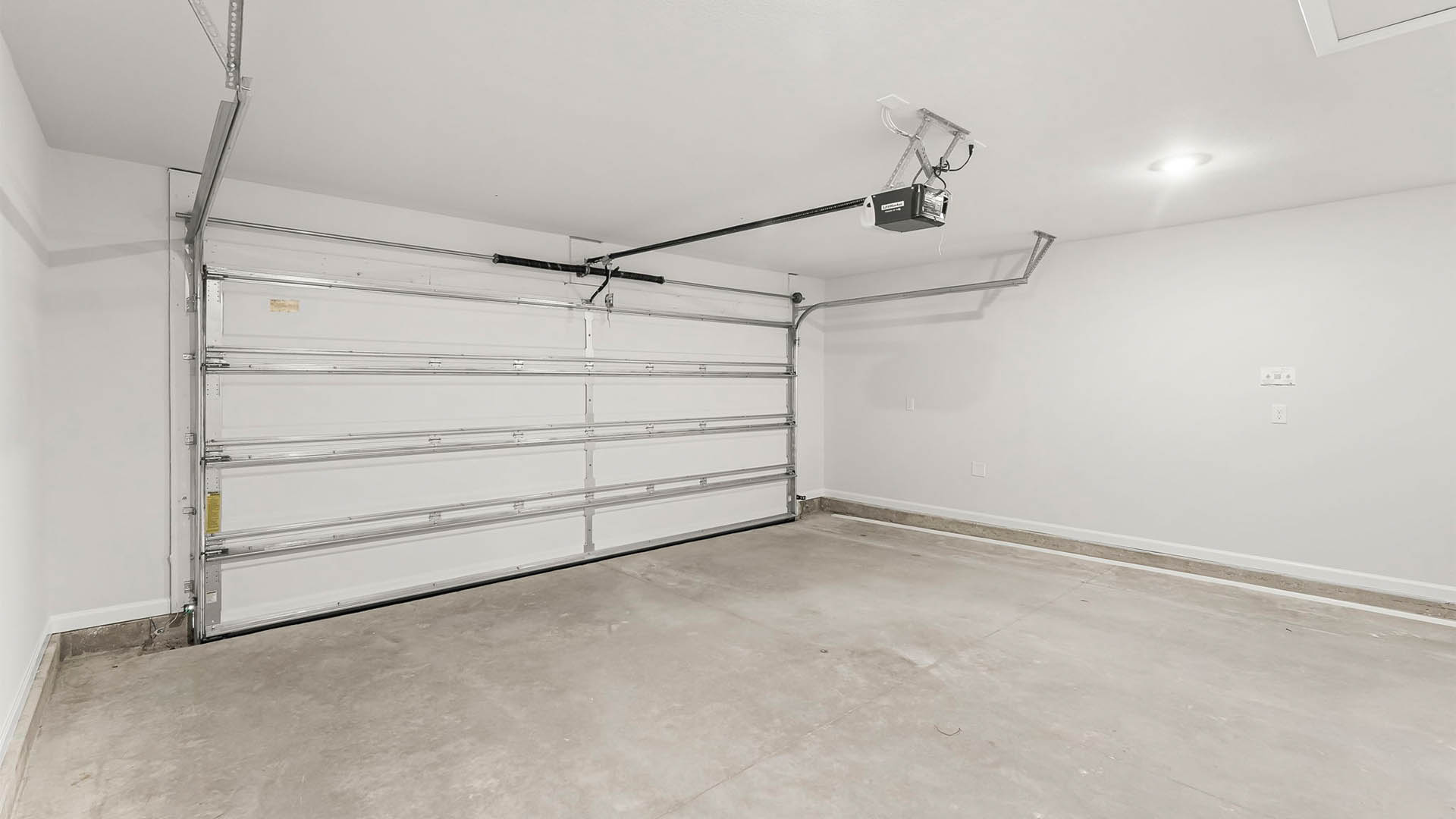Two-car garage with door and attic space.