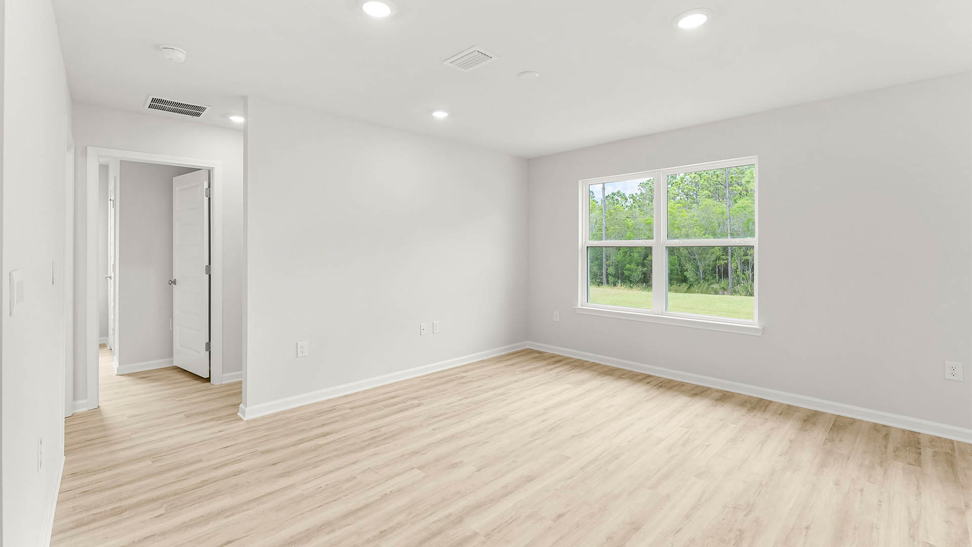 Living room with EVP flooring next to bedrooms and window.