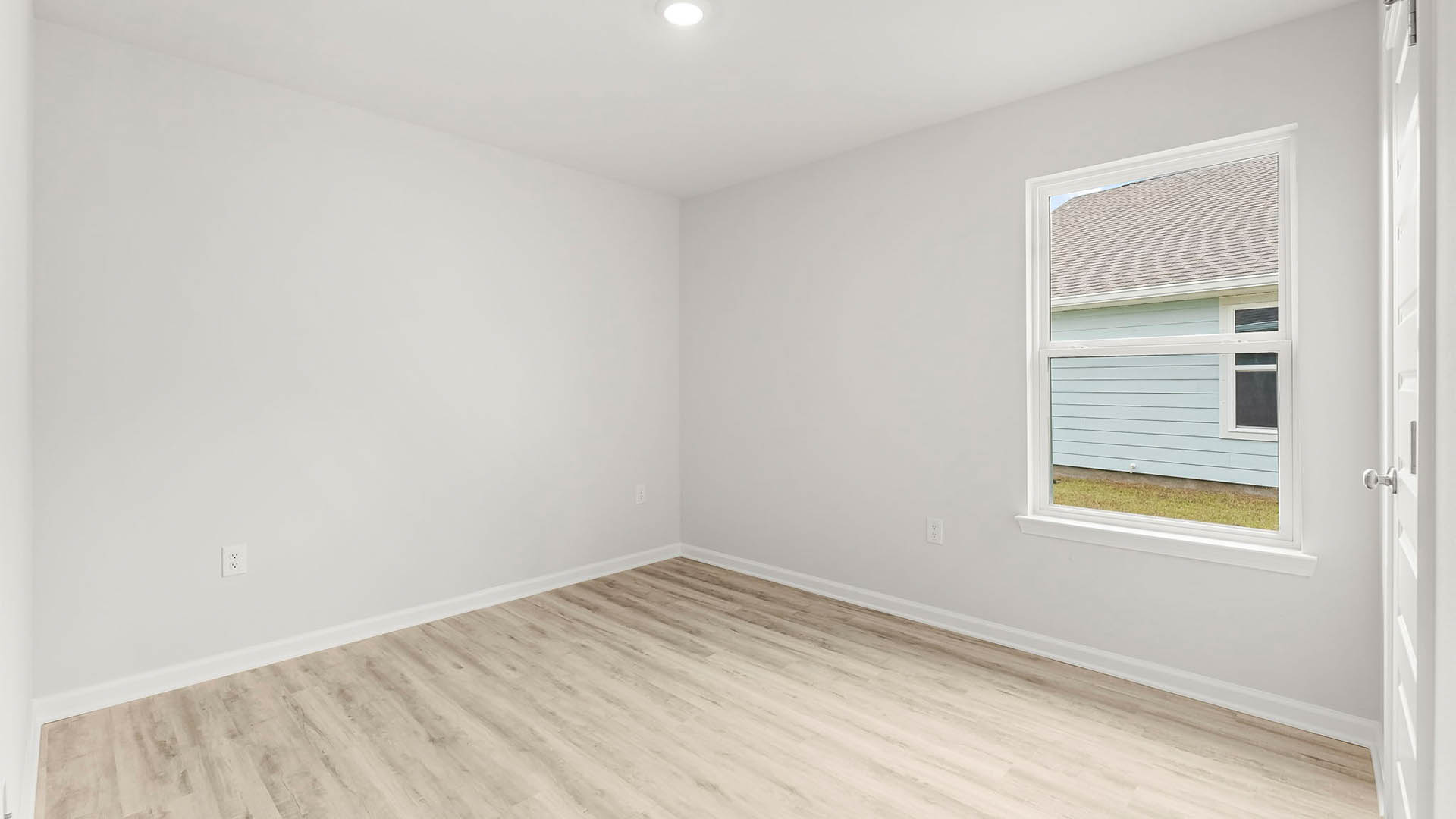 Bedroom with EVP flooring and window and closet.