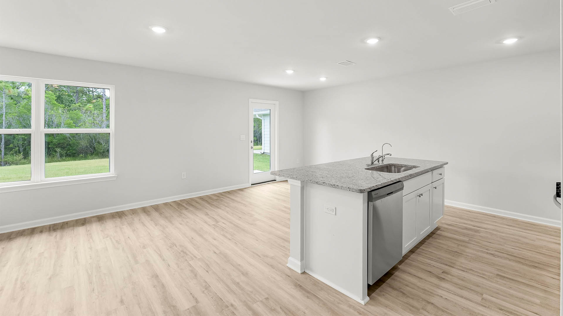 Kitchen and dining room with island and granite countertops and stainless-steel appliances.