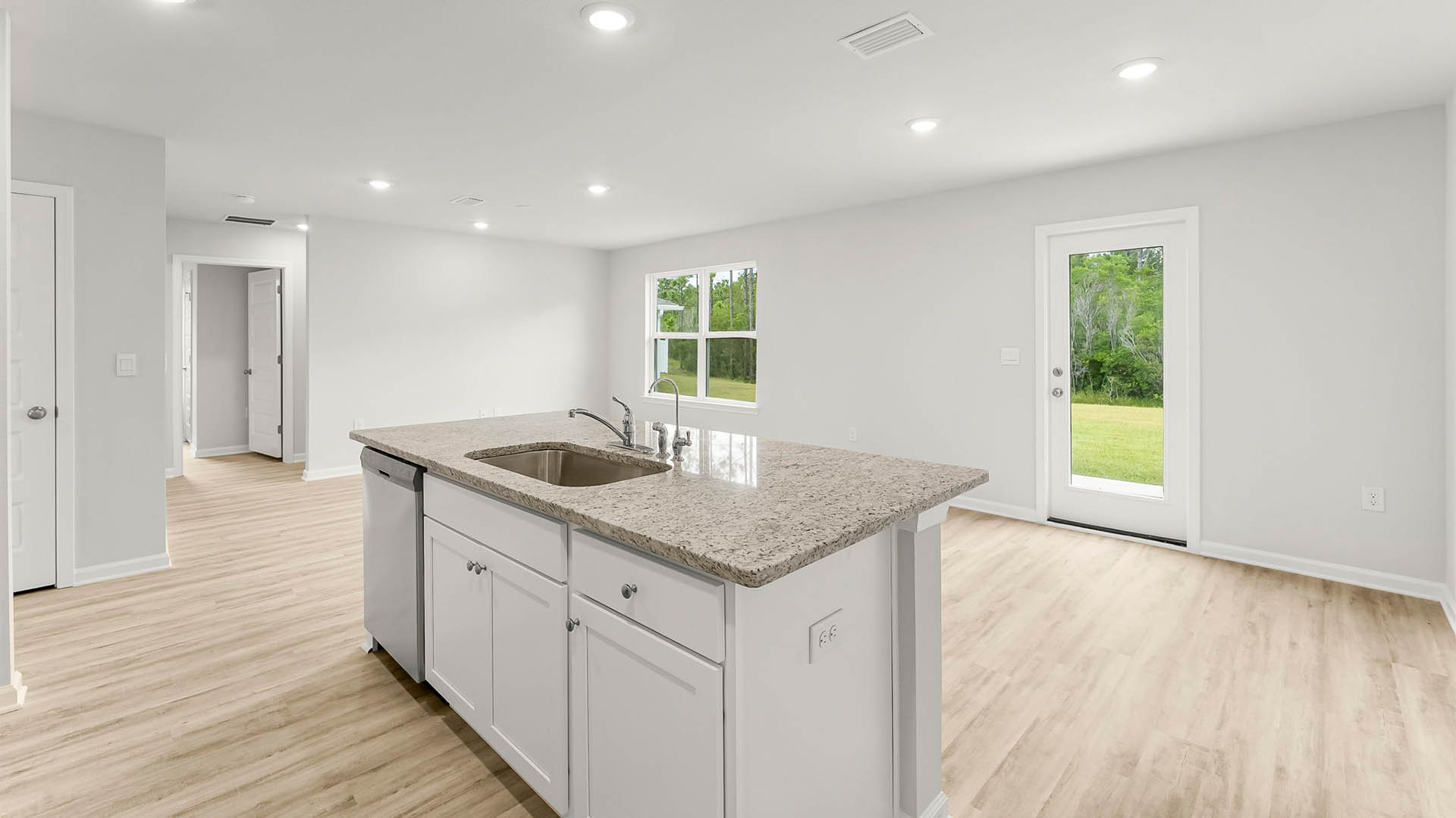 Kitchen showing island and dining room and living room and back door.