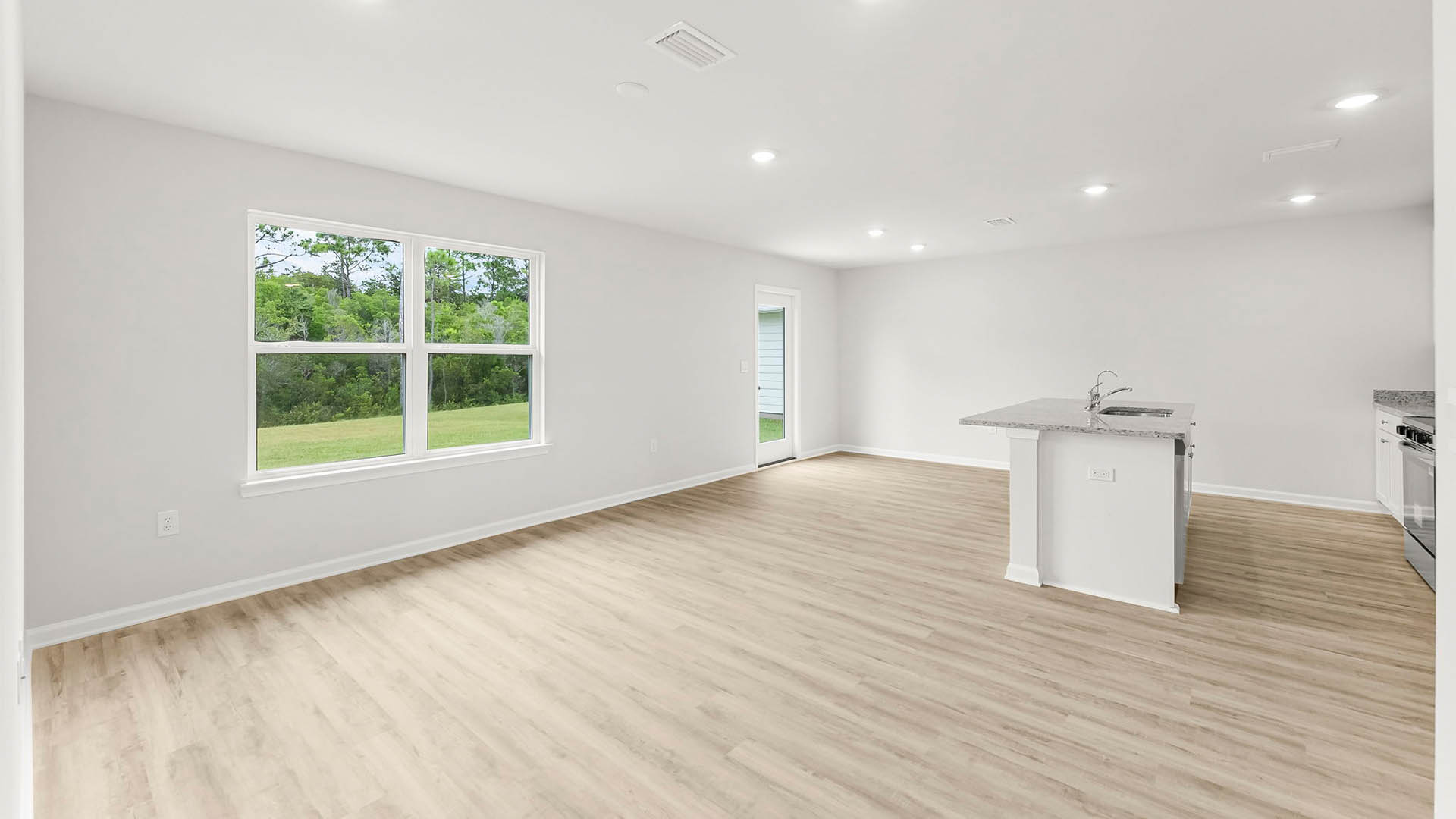 Living room view of kitchen and dining area next to bedrooms.