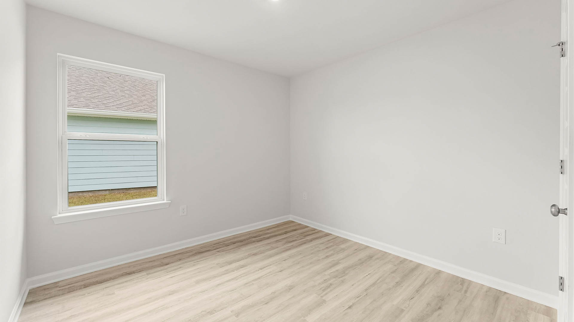 Bedroom with EVP flooring and window and closet.