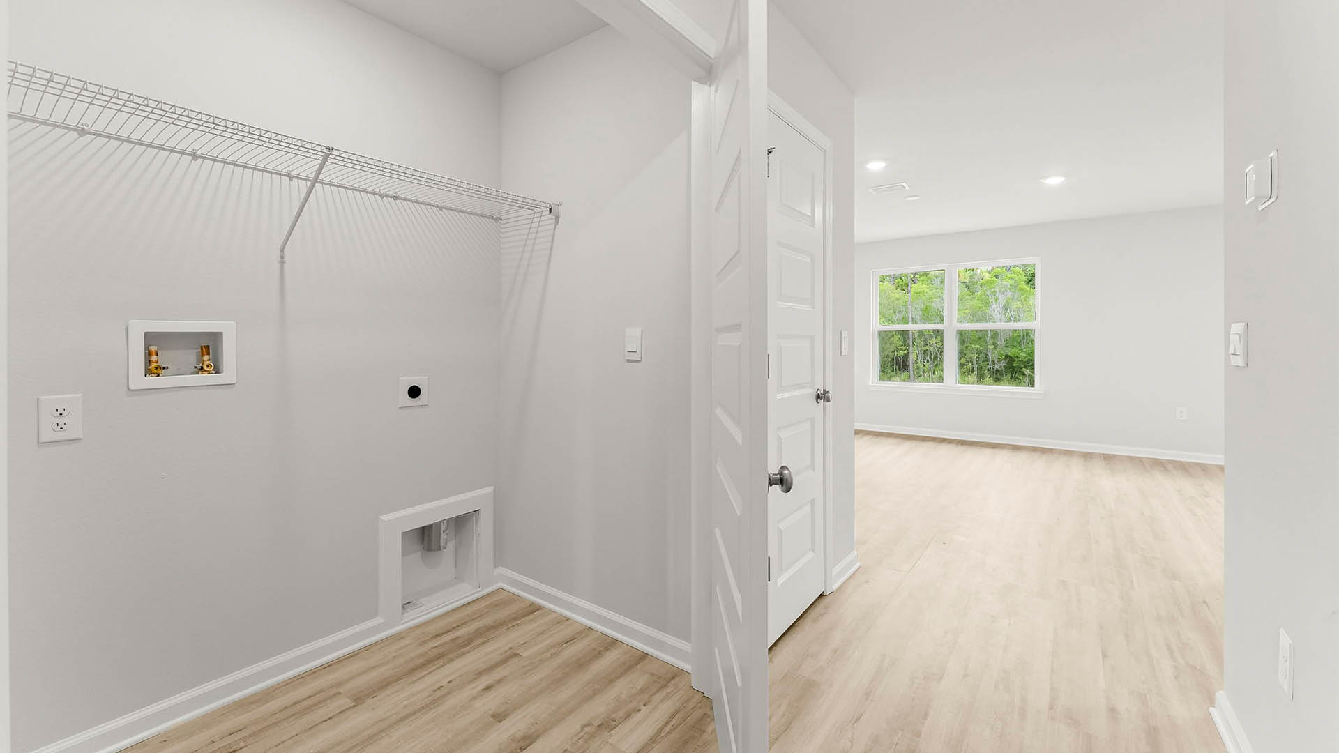Hallway with laundry room with EVP flooring and ventilated shelving.