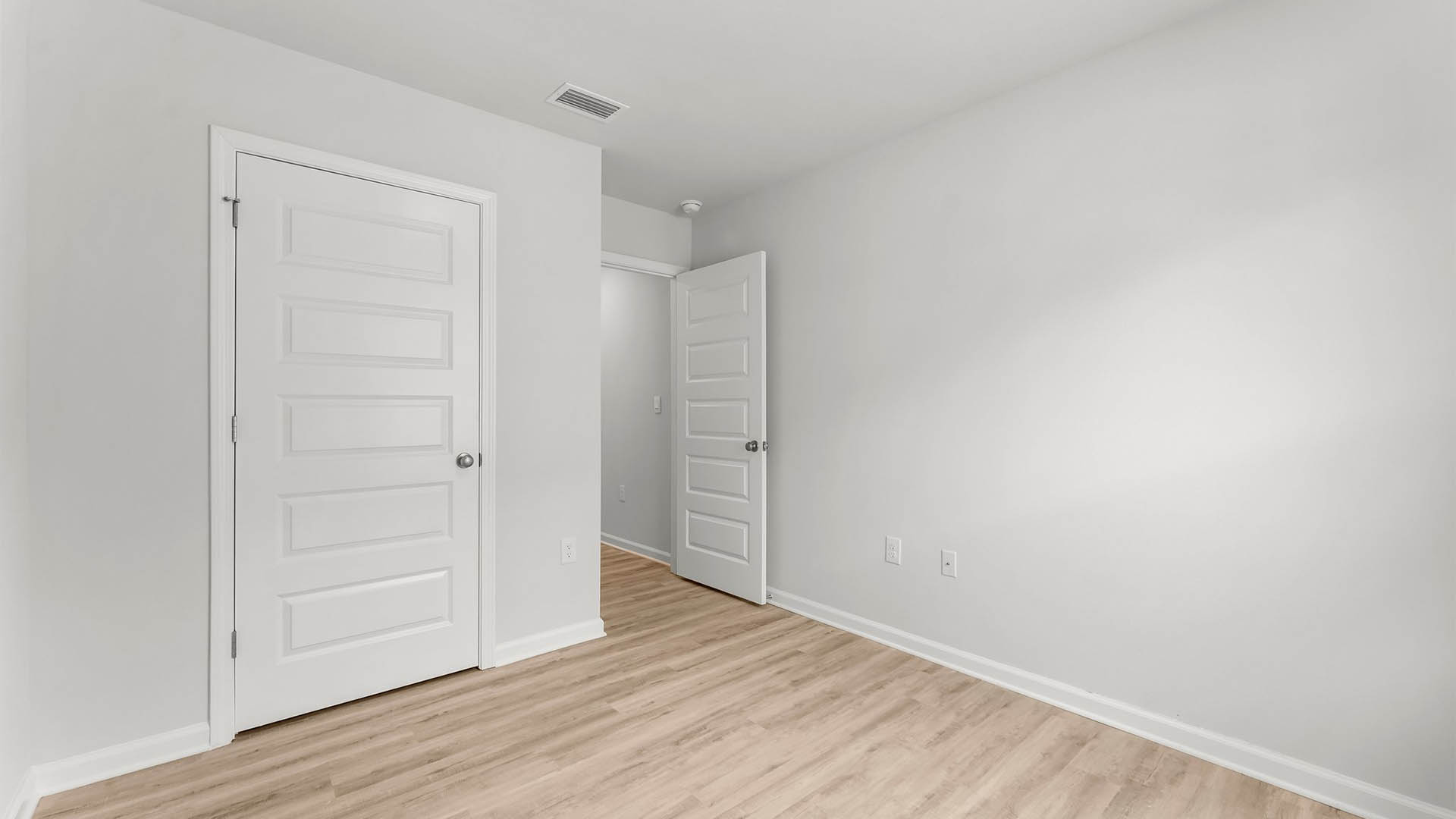 Bedroom with EVP flooring and closet.