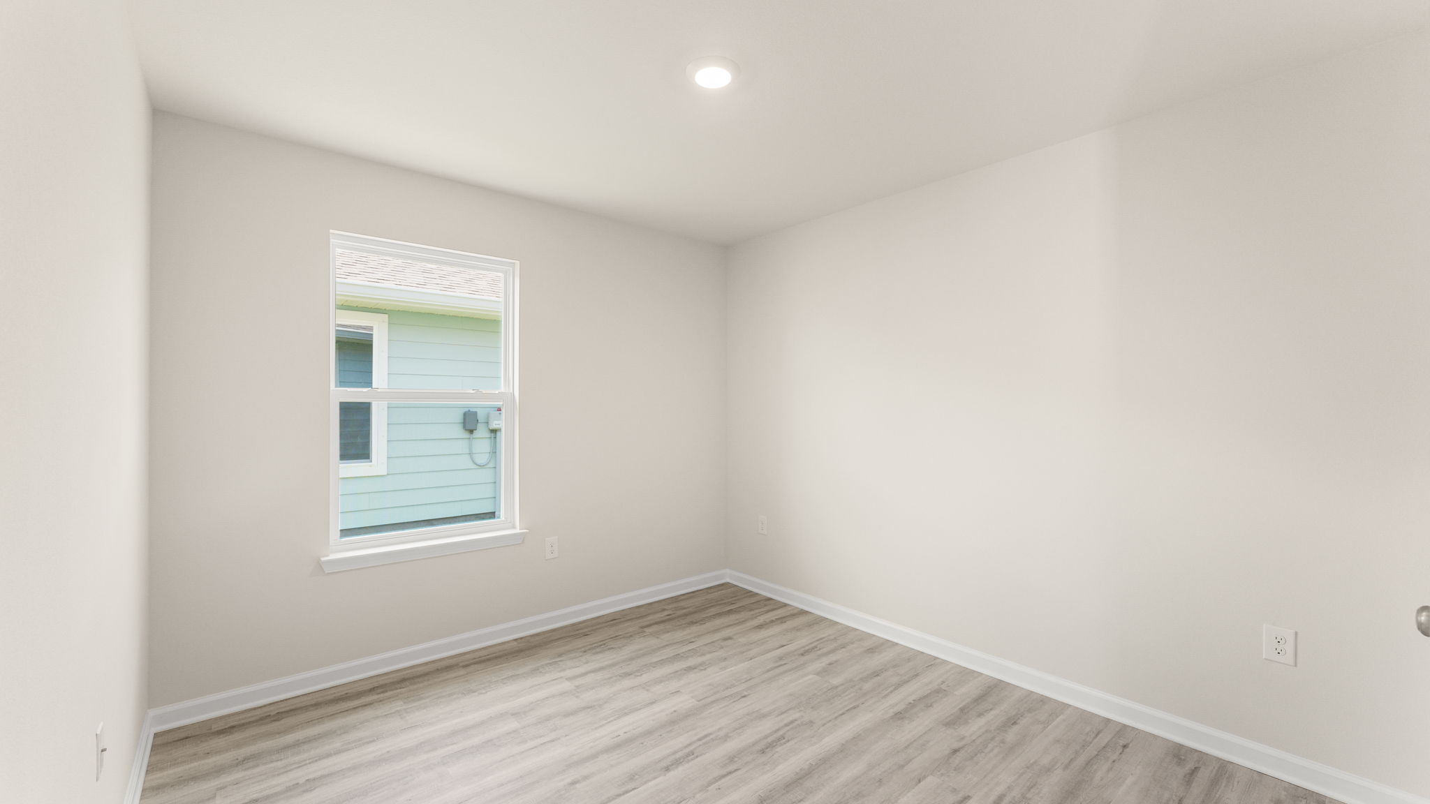 Bedroom with EVP flooring and window.