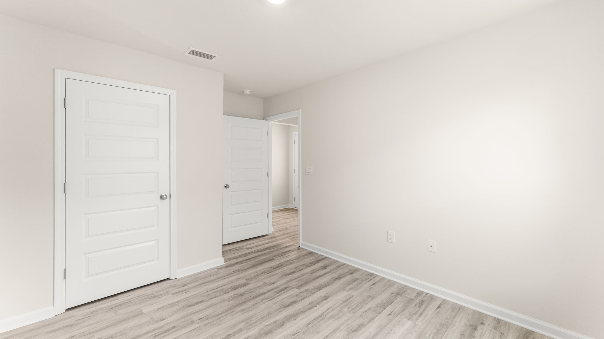 Bedroom with EVP flooring and closet.
