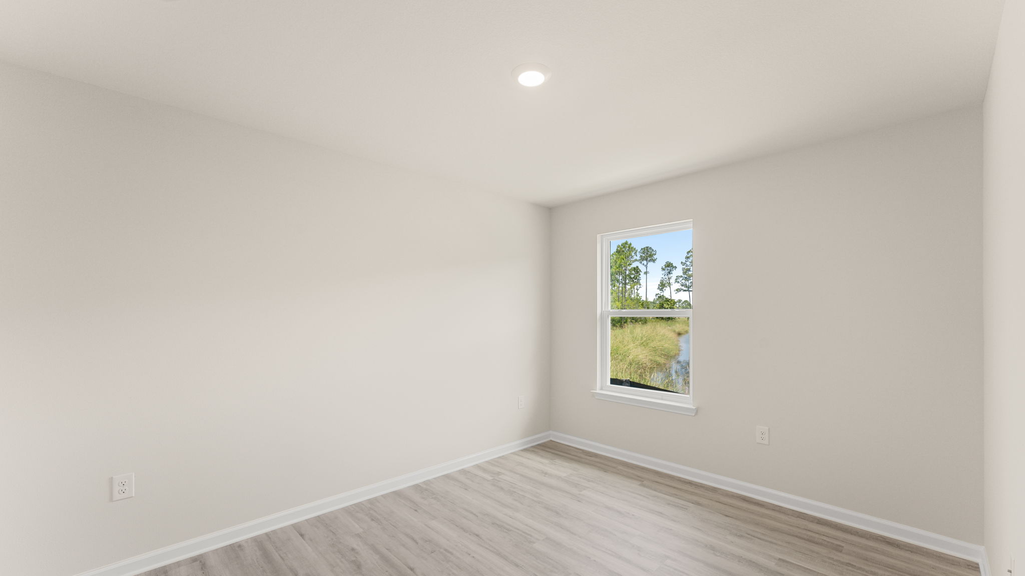 Bedroom with EVP flooring and window.