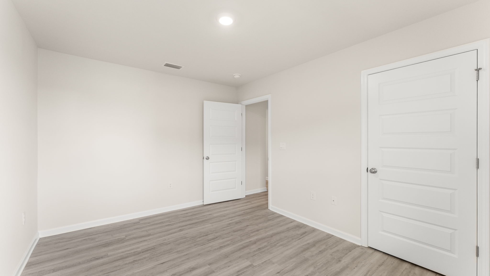 Bedroom with EVP flooring and closet.