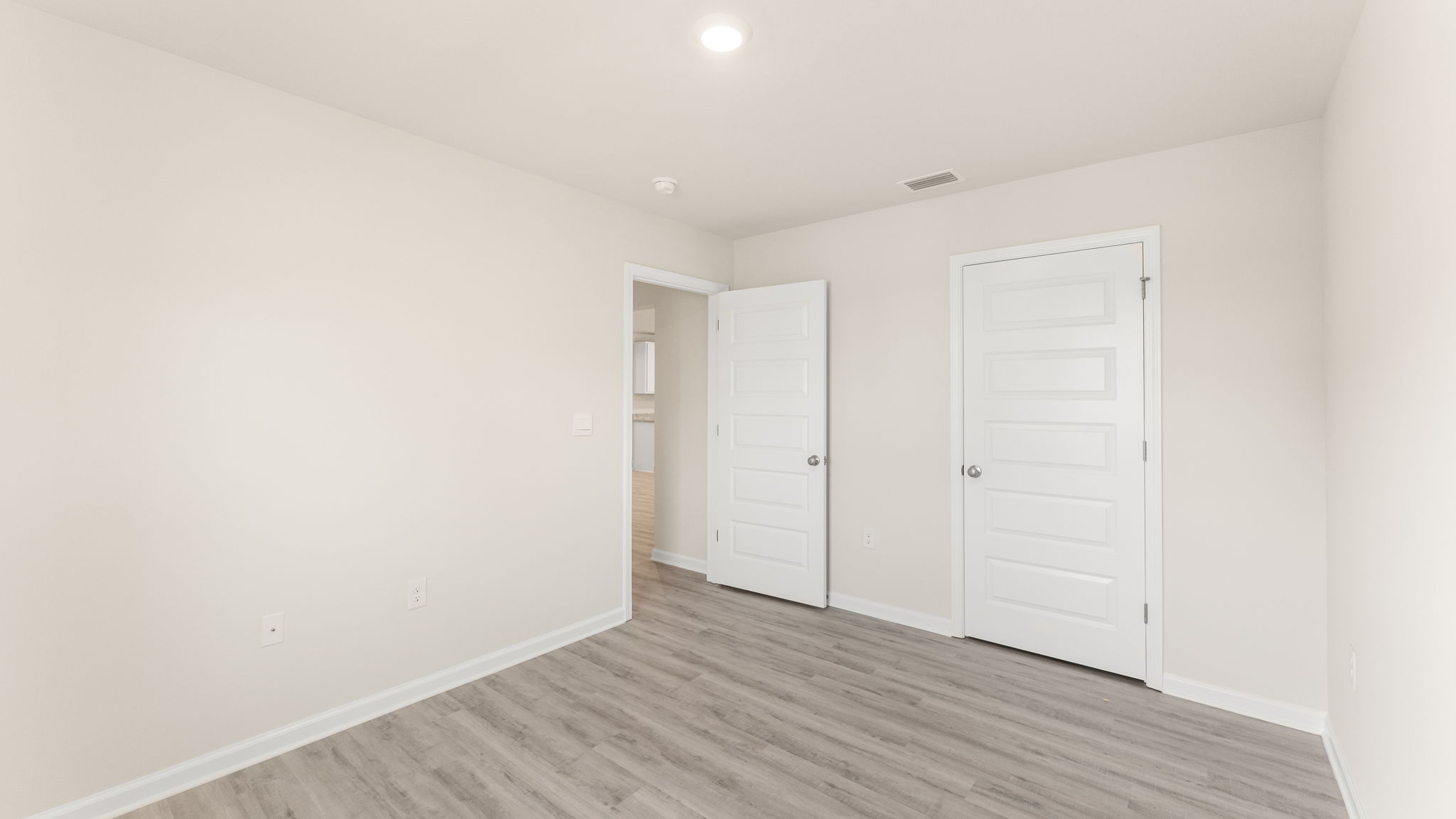 Bedroom with EVP flooring and closet.