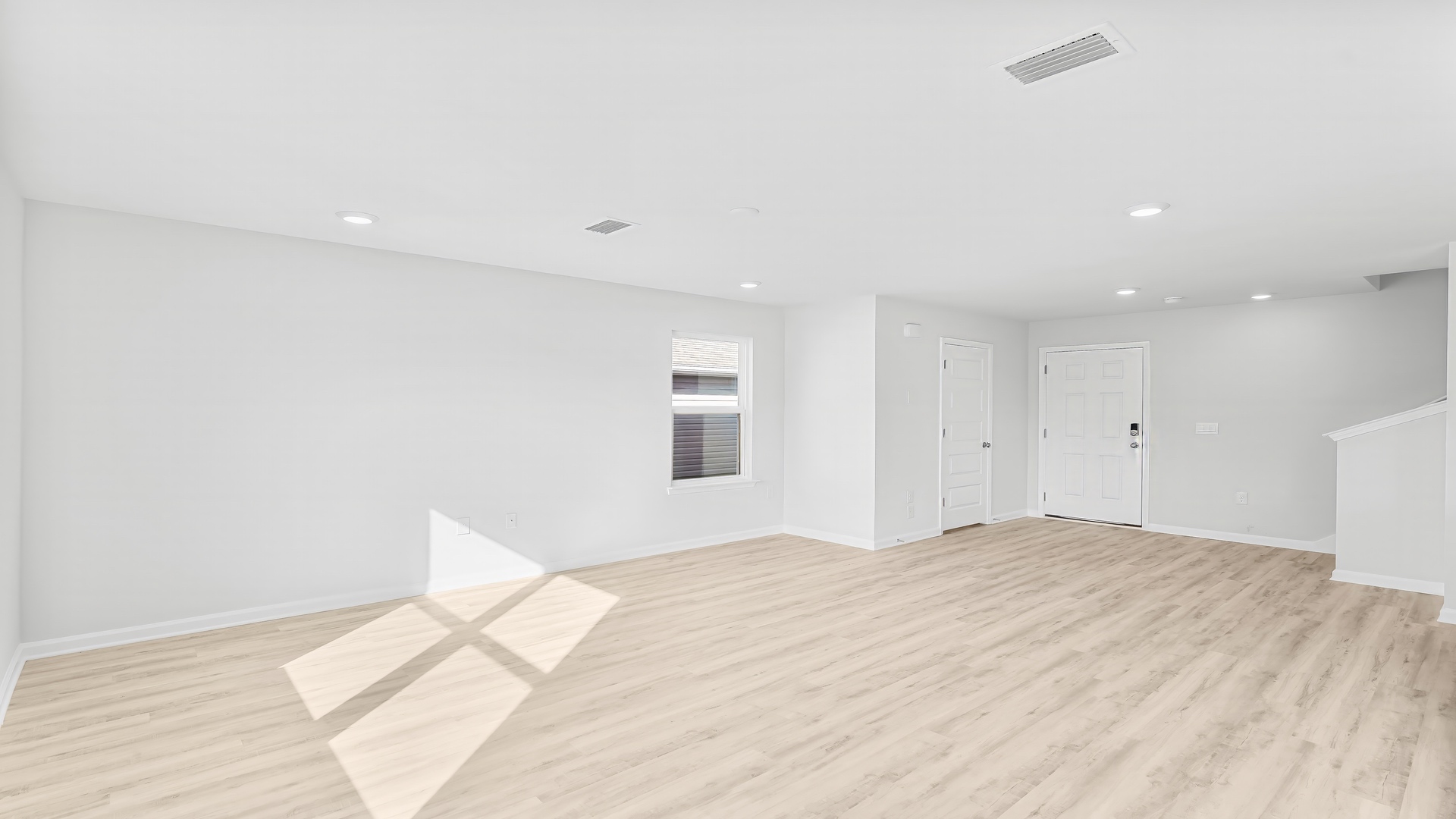 Open living room with EVP flooring and bathroom by front door.