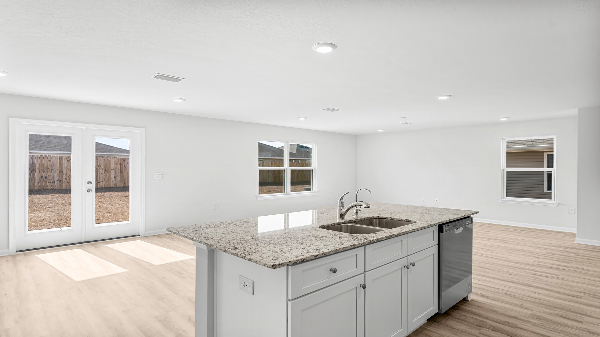 Open living room with EVP flooring and kitchen and dining area.