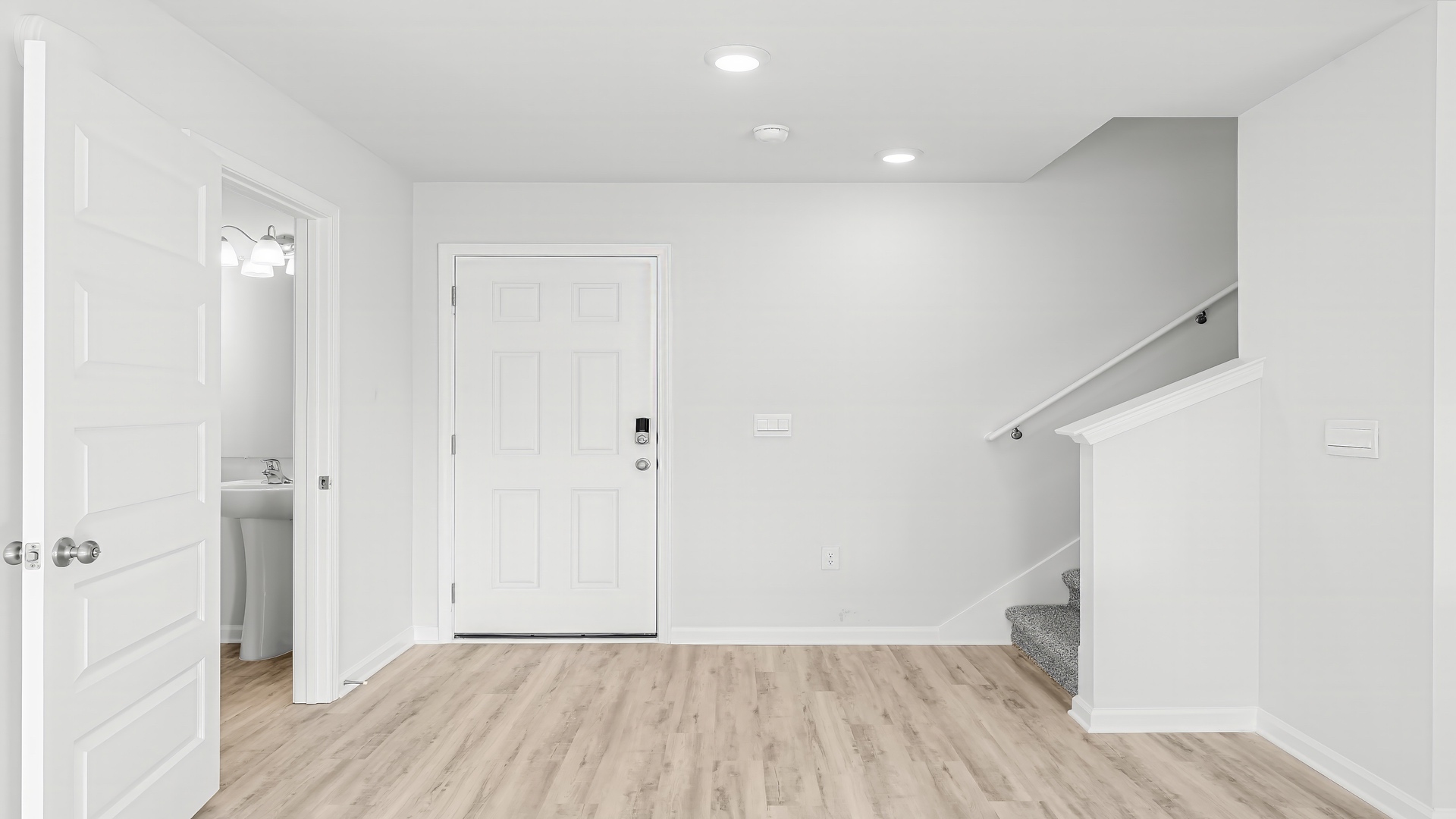 Front door next to staircase and bathroom.