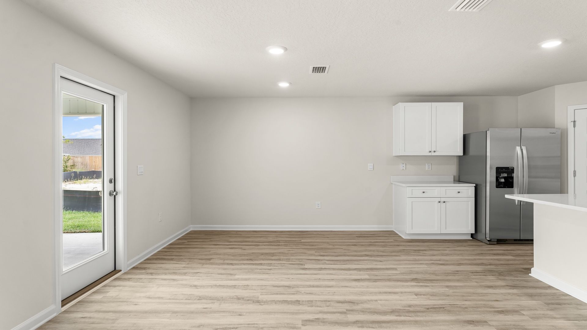 Dining area with EVP flooring next to kitchen and back door.