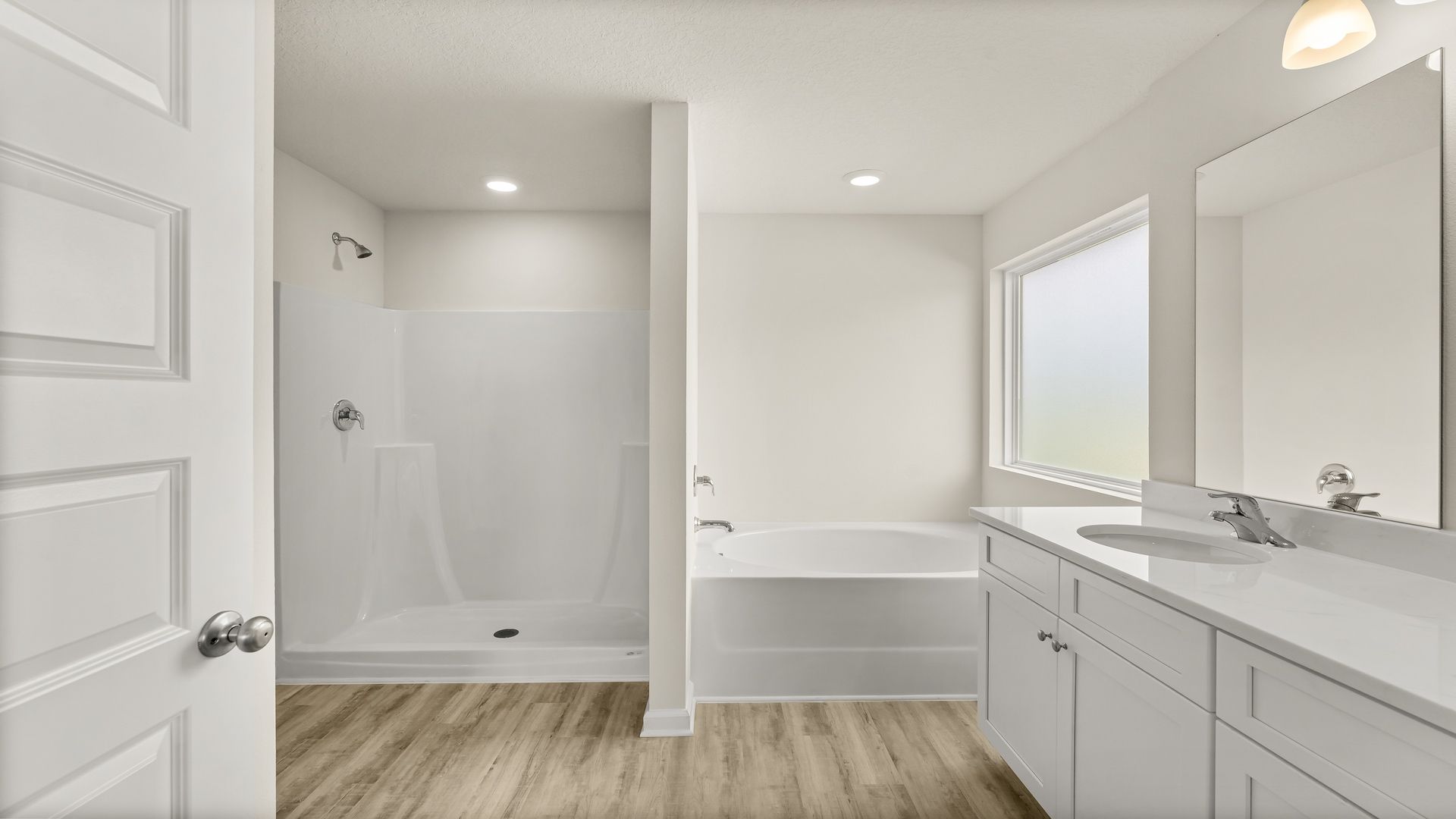 Primary bathroom with quartz countertops and double vanity and tub and shower.