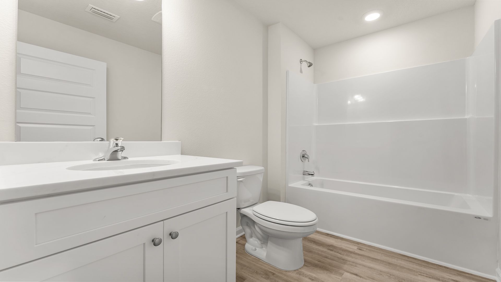Bathroom with EVP flooring and quartz countertops and single vanity and shower.