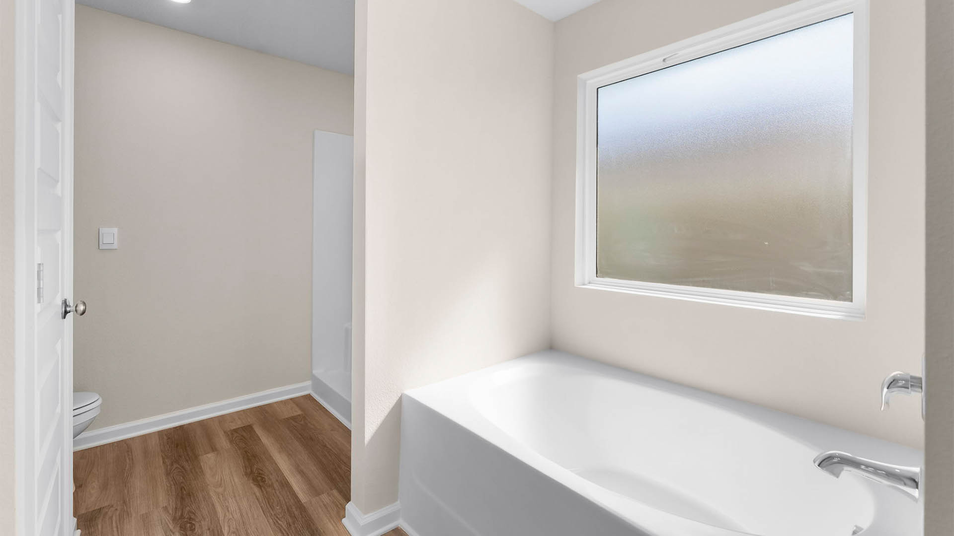 Primary bathroom tub and frosted mirror.