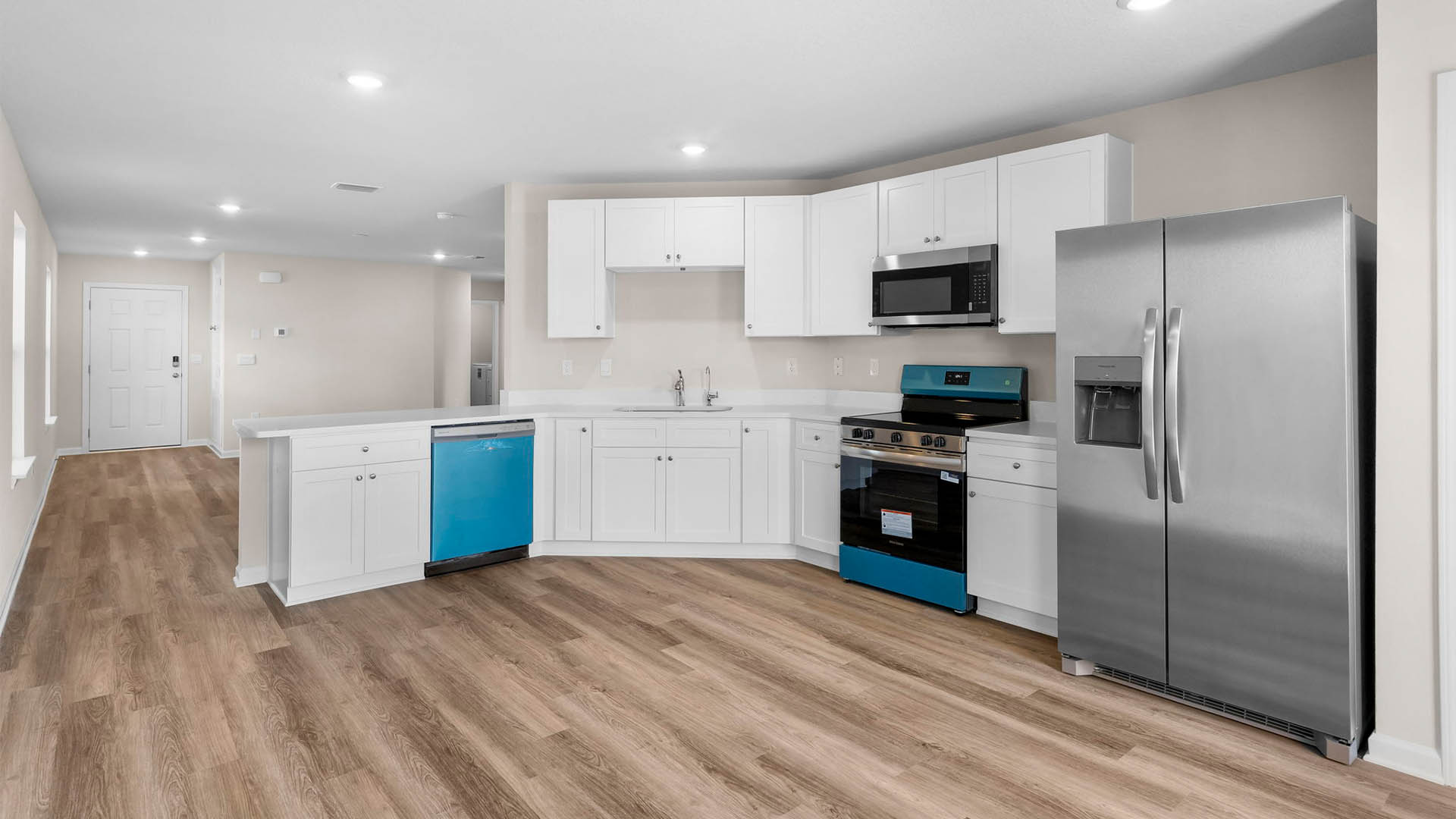 Kitchen with quartz countertops and white cabinets with stainless steel appliances.