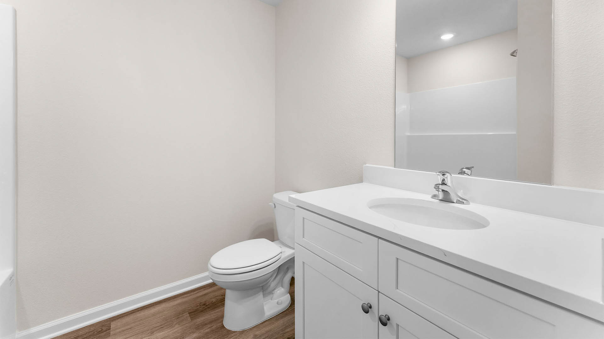 Bathroom with single vanity quartz countertop and toilet and shower tub combo.