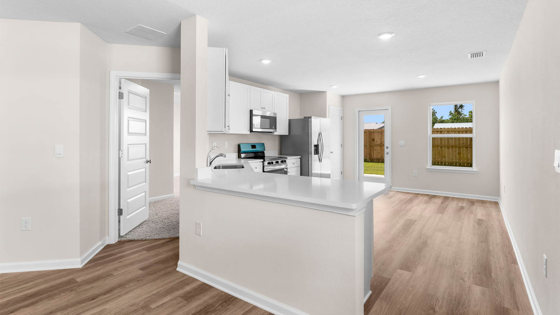 Primary bedroom entrance next to kitchen with quartz countertop.