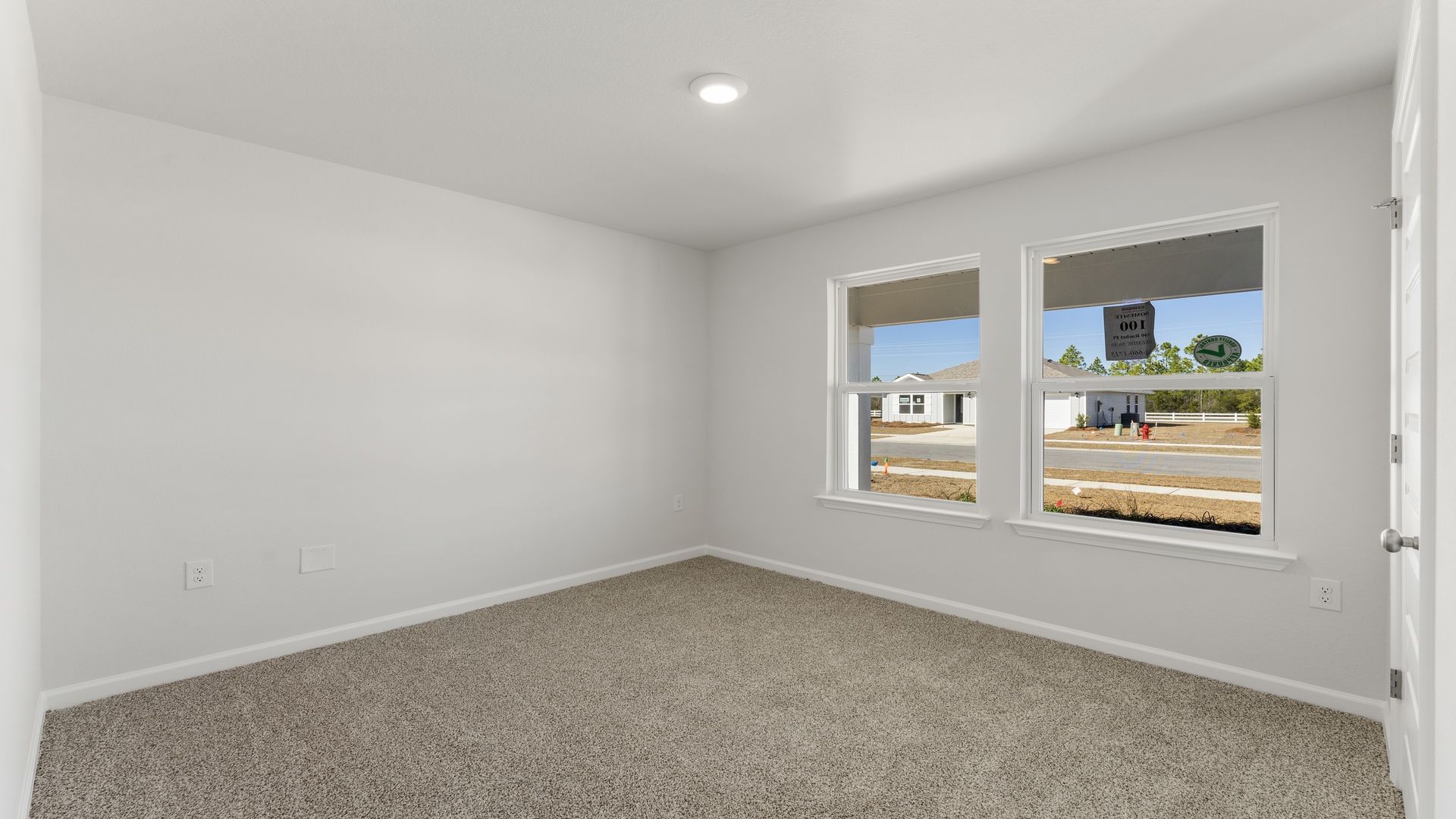 Front bedroom with carpet floor and two windows.