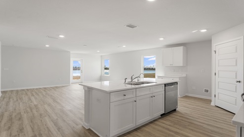 Kitchen island with quartz countertops and stainless-steel appliances.