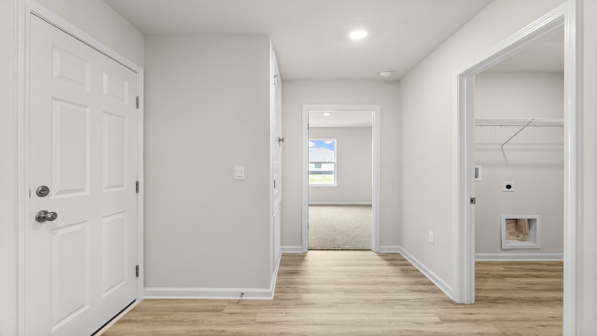 Hallway next to laundry room and garage and bedroom.