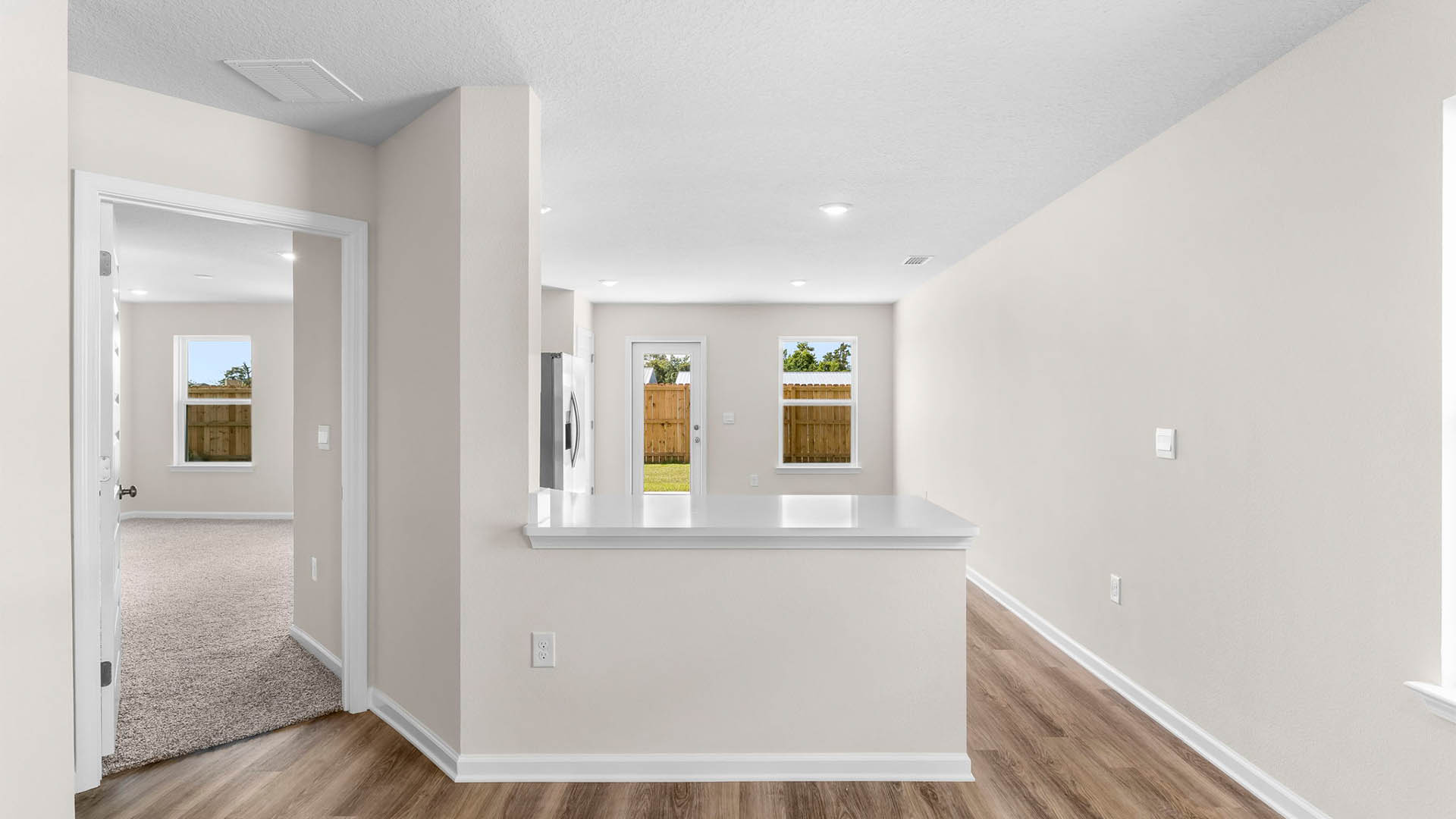 Primary bedroom entrance next to kitchen with quartz countertop.