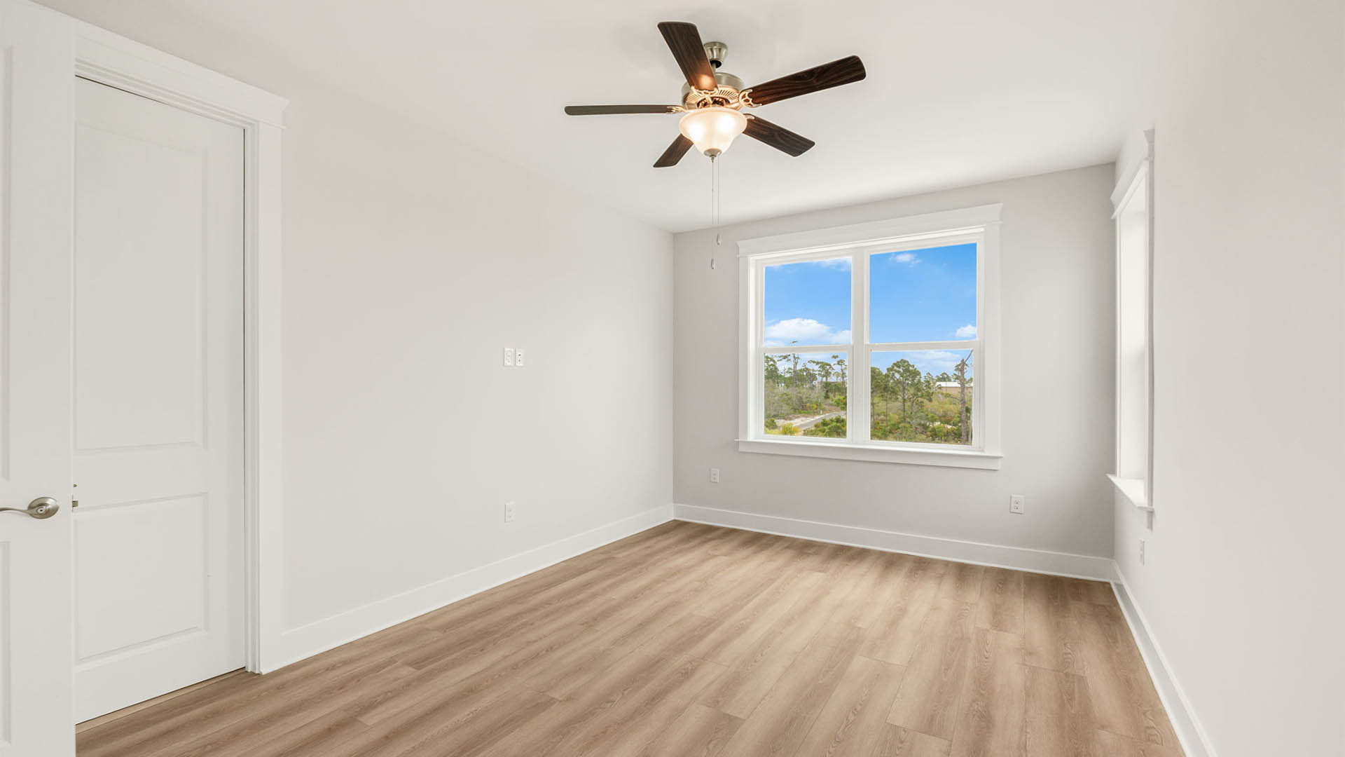 Bedroom with ceiling fan and EVP flooring.