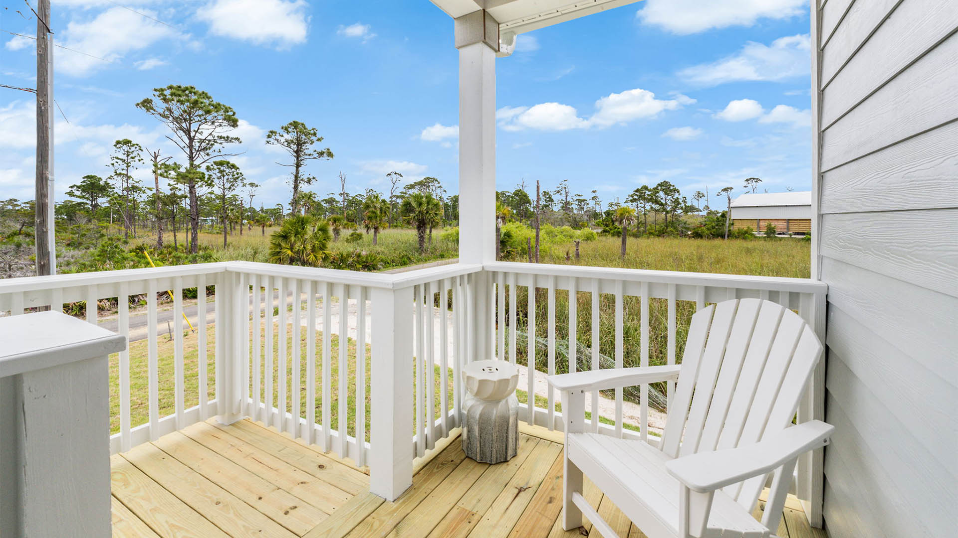 Covered back patio with white patio furniture.
