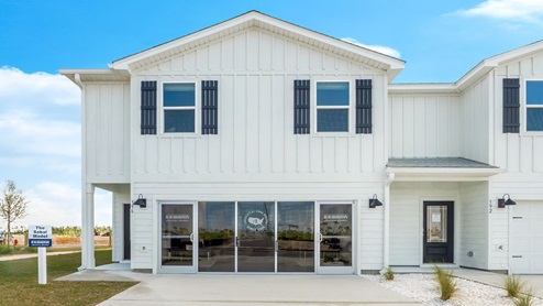 Two-story townhome with 2-car garage and white Hardie Board siding.