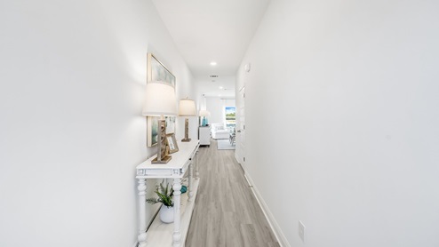 Front hallway with white furniture and picture in model home.