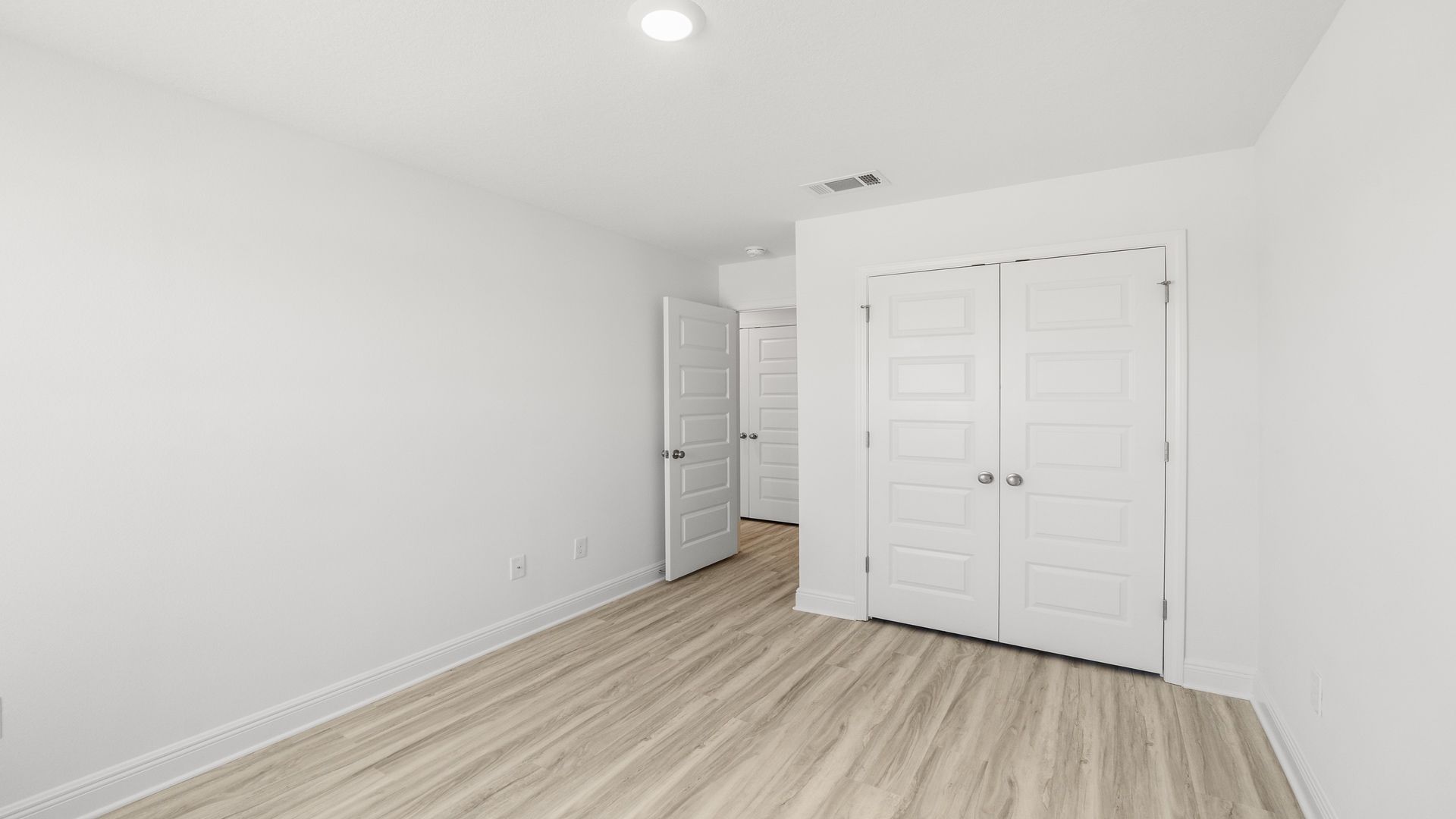 Bedroom with EVP flooring and closet.
