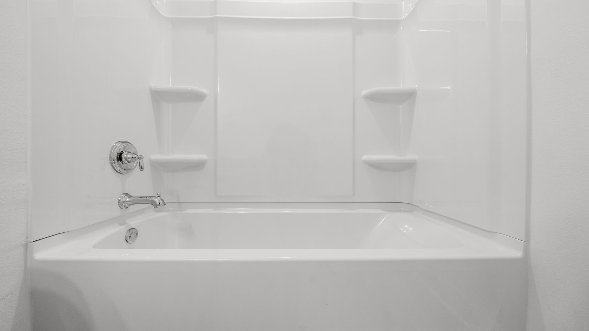 Shower with chrome faucet and handle.