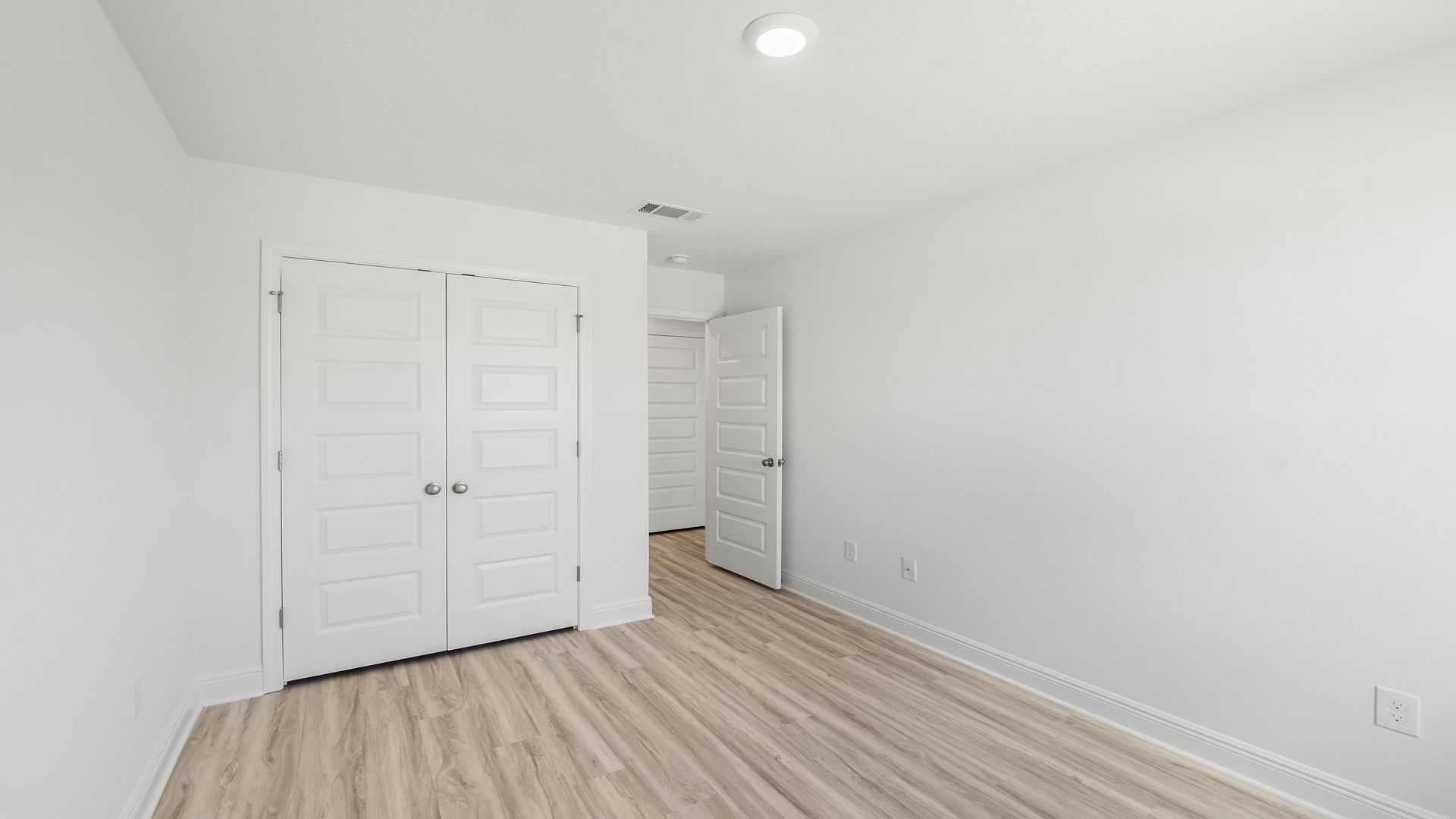 Bedroom with EVP flooring and closet.