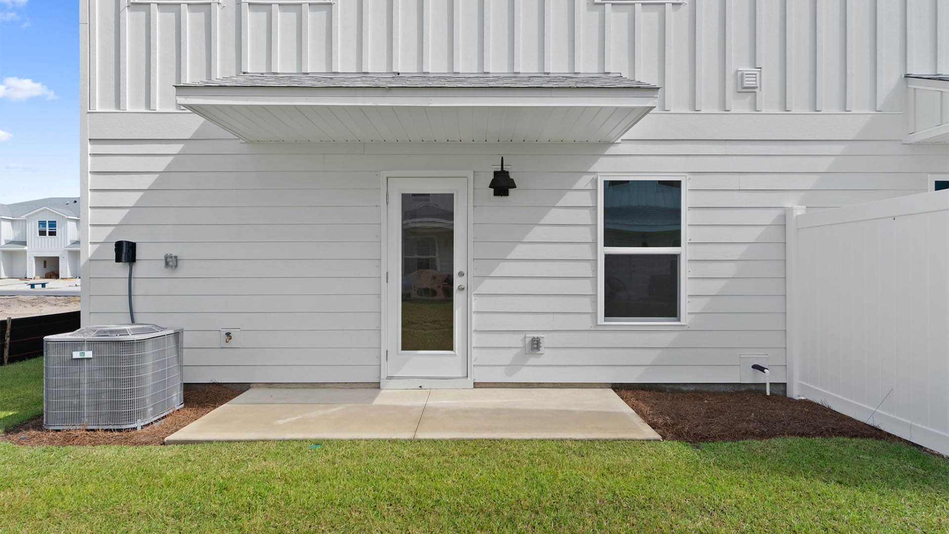 Covered back porch with air-conditioning unit.