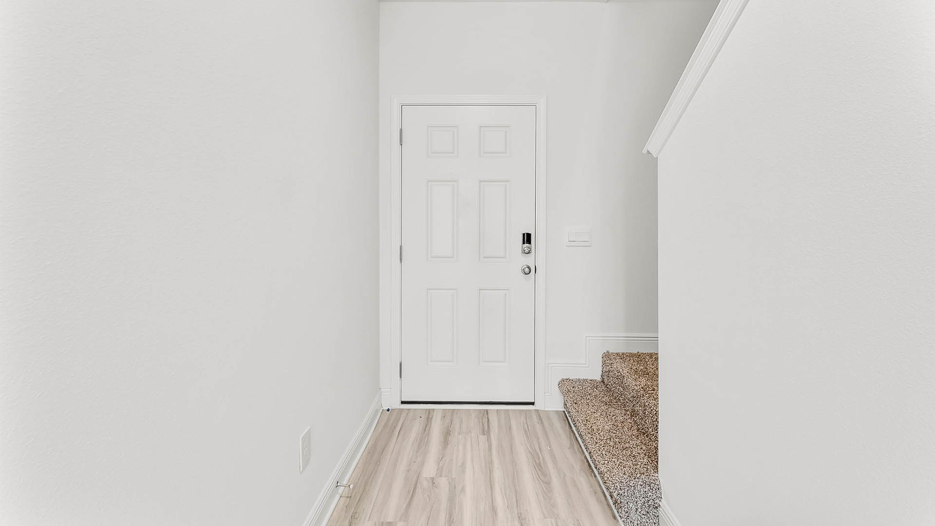 Front entrance hallway with EVP flooring next to carpeted stairs.