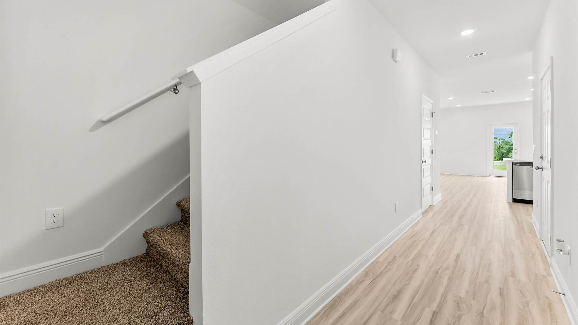 Front entrance hallway with EVP flooring next to carpeted stairs.