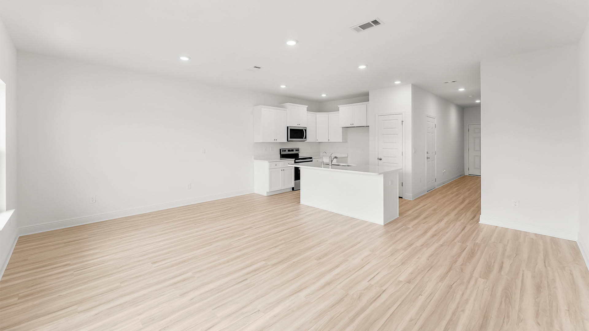 Open living room with EVP flooring and kitchen.