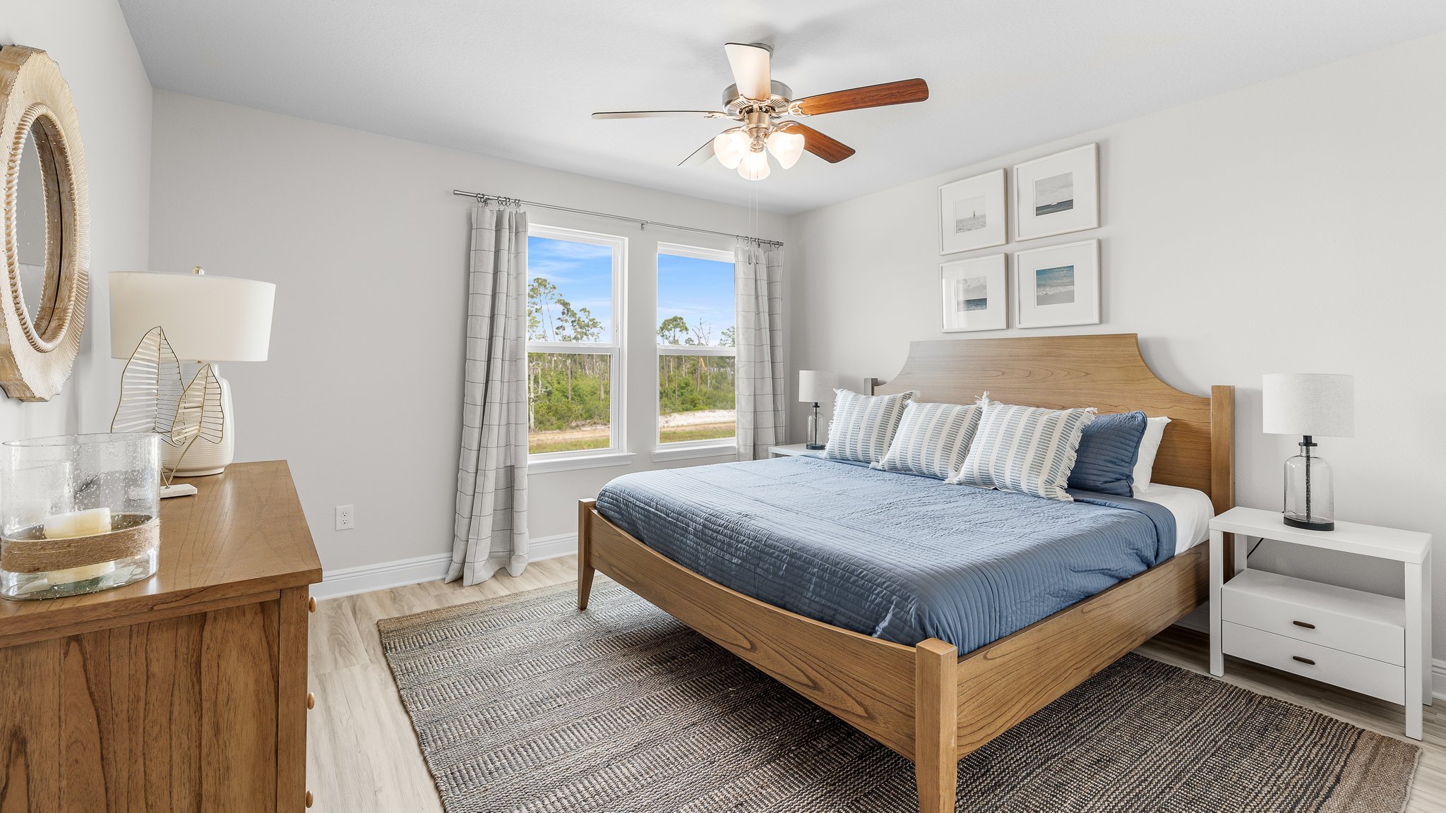 Primary bedroom with ceiling fan and EVP flooring and windows.