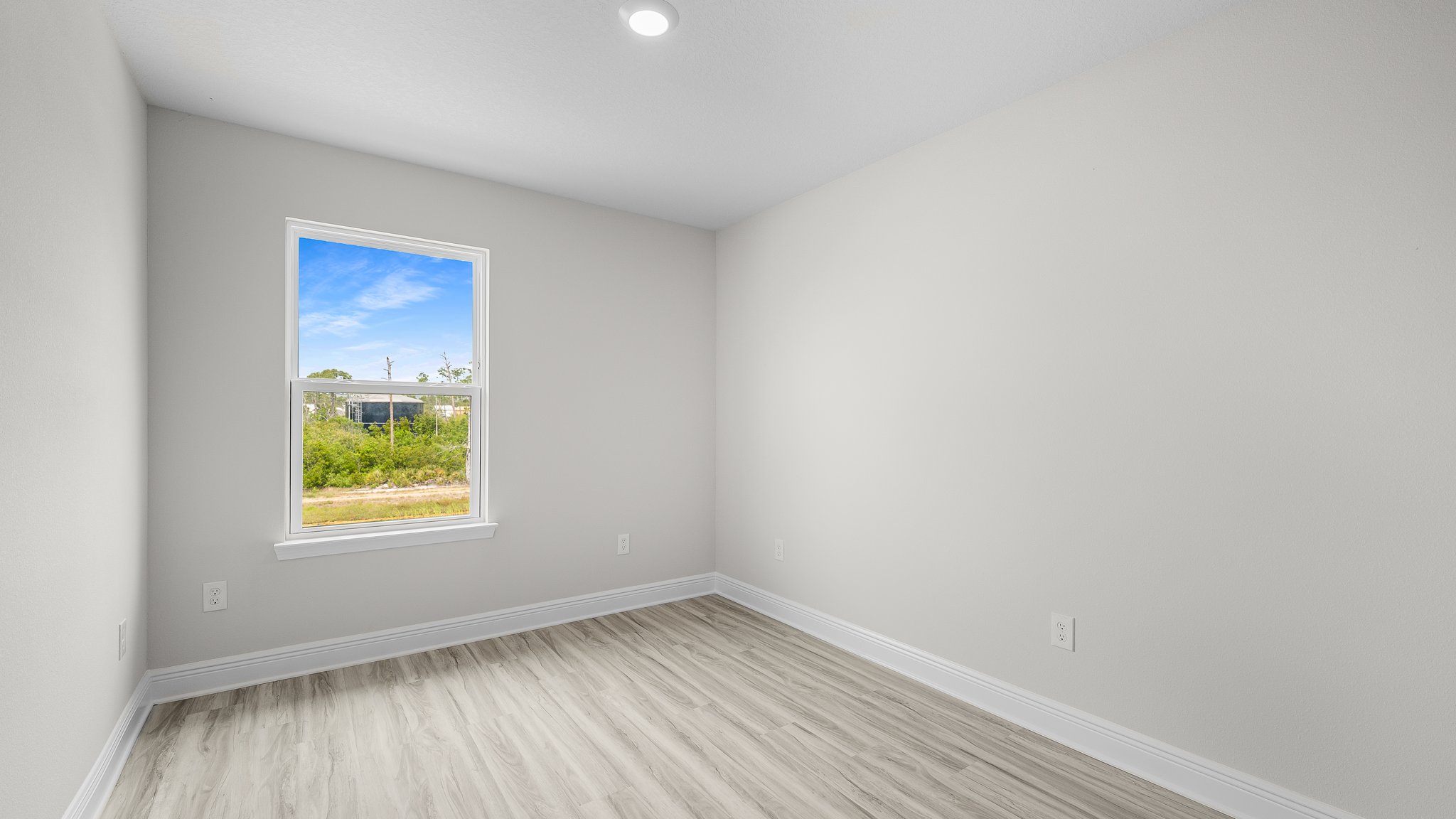 Bedroom with EVP flooring and window.