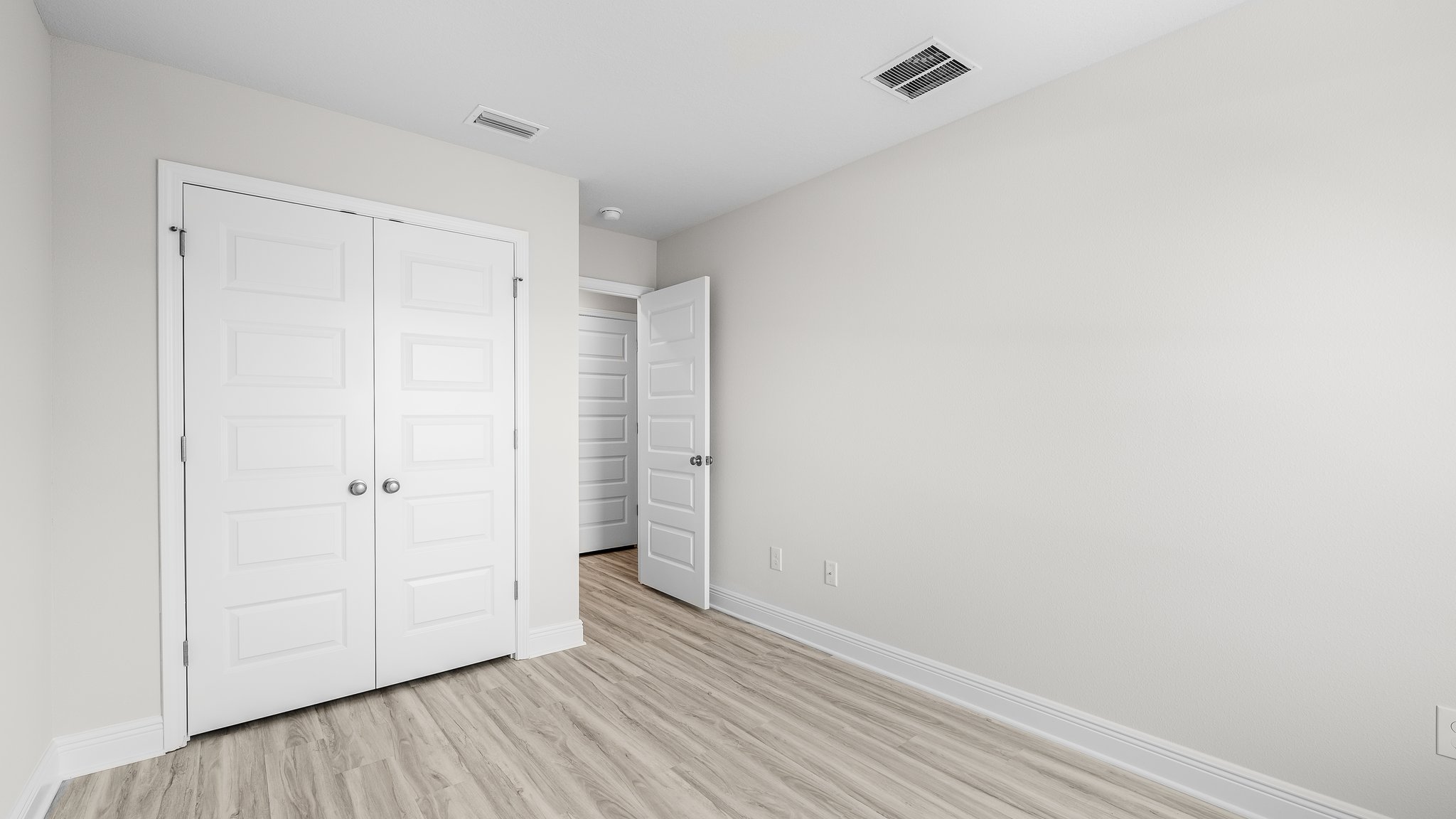 Bedroom with EVP flooring and closet.